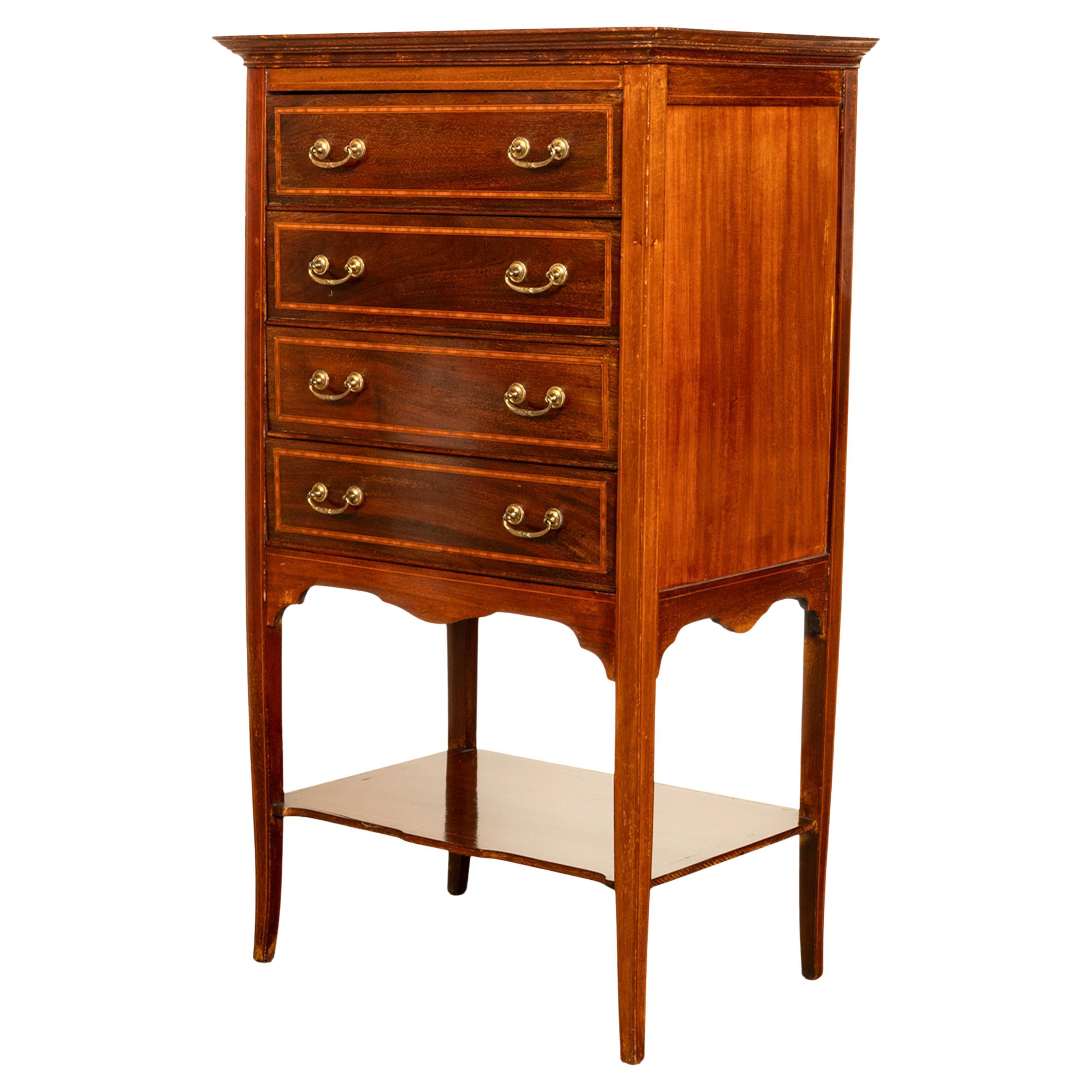 Un'antica cassettiera per spartiti o schedari in mogano intarsiato di Sheraton Revival, circa 1900.
Il mobile presenta un'incorniciatura in legno satinato nella parte superiore, mentre al di sotto si trovano quattro cassetti scorrevoli con frontali