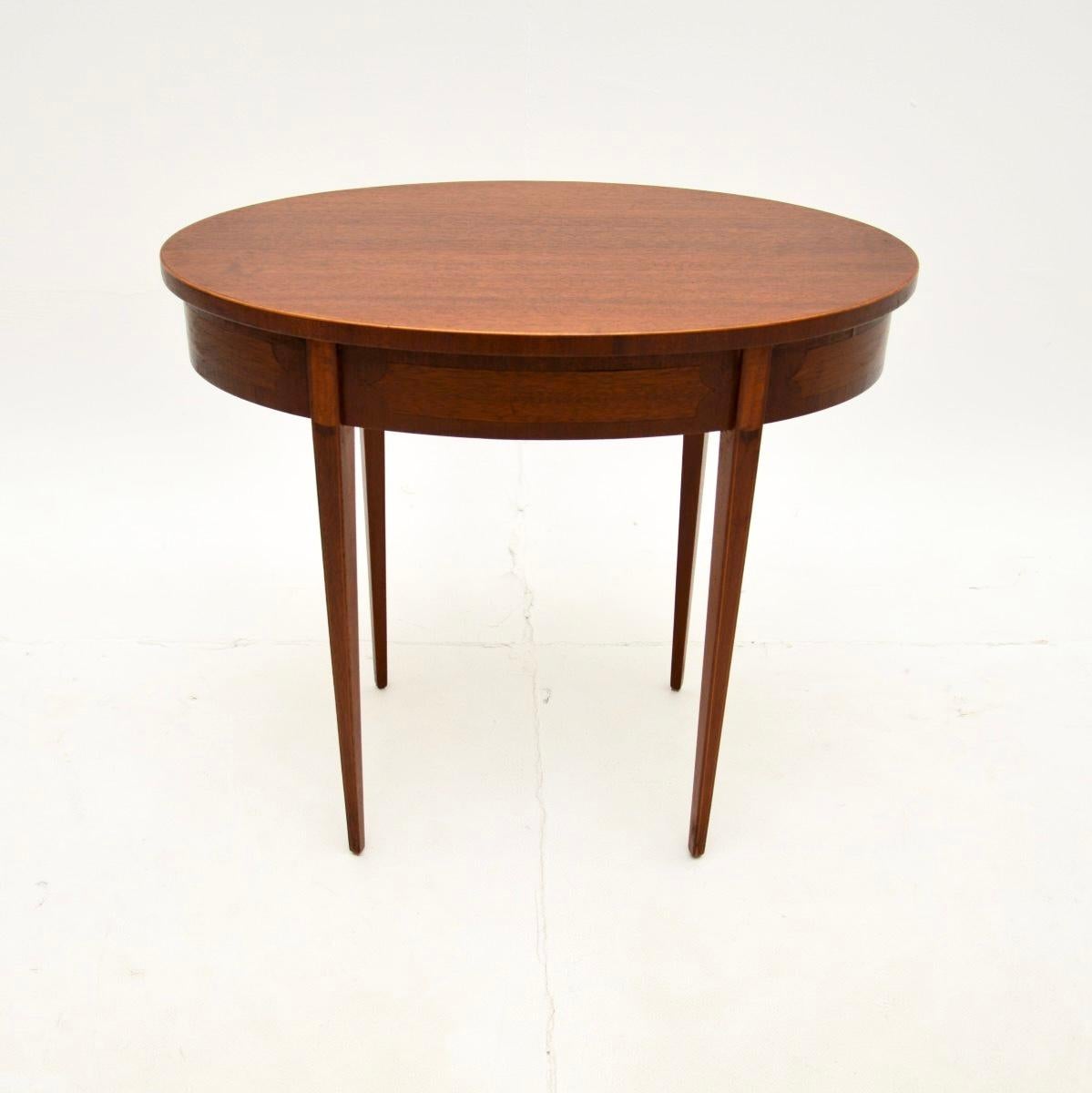 A beautiful and elegant antique Edwardian side table. This was made in England, it dates from around 1900-1910.

It is of lovely quality and is a very useful size to be used as a side table or coffee table. The oval top has satinwood inlays around
