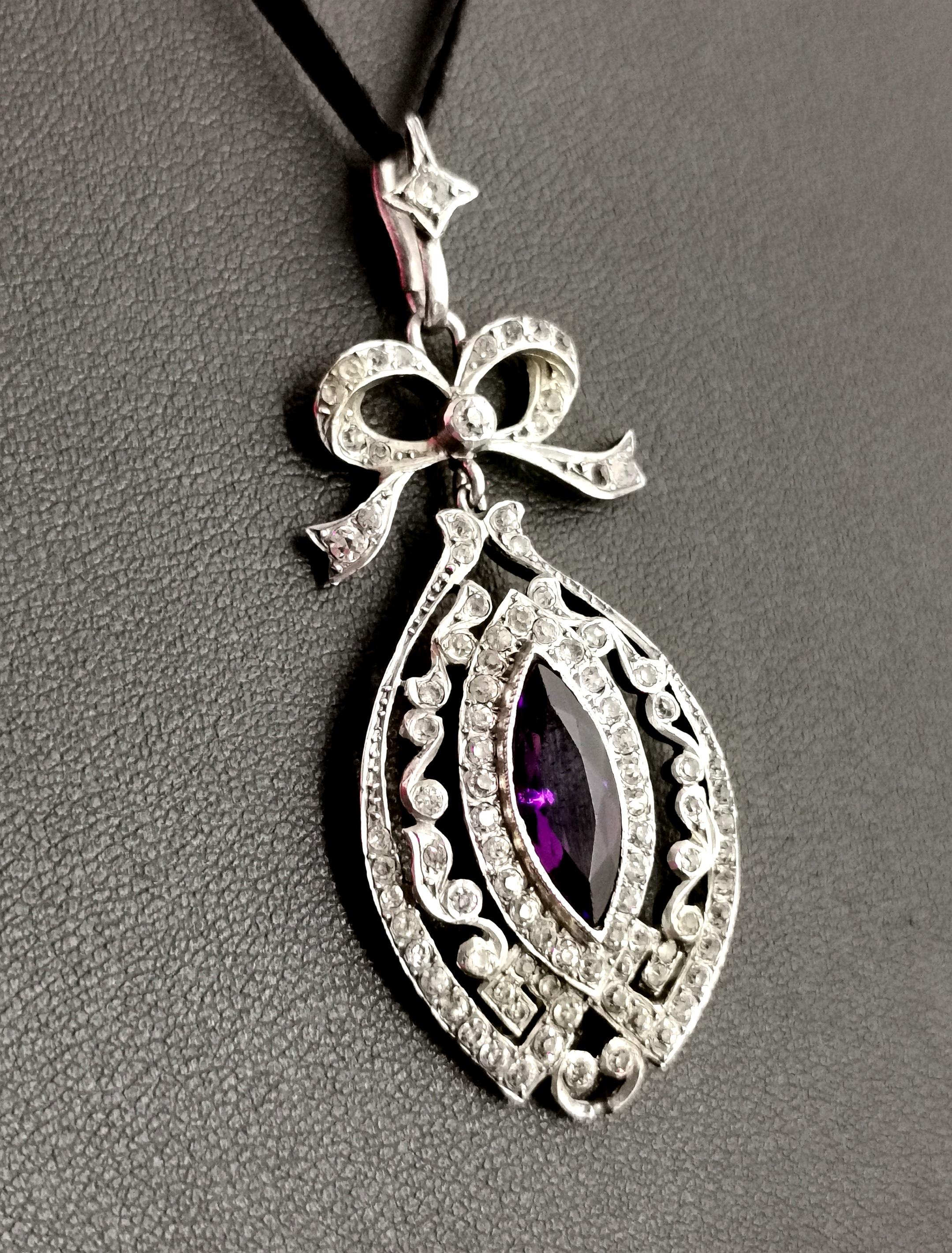 A divine Antique Edwardian silver paste pendant.

A belle epoque style piece, it has a large ellpise shaped drop set with a faceted Amethyst paste stone to the centre.

The deep purple paste is surrounded by a border of sparkling diamond paste and