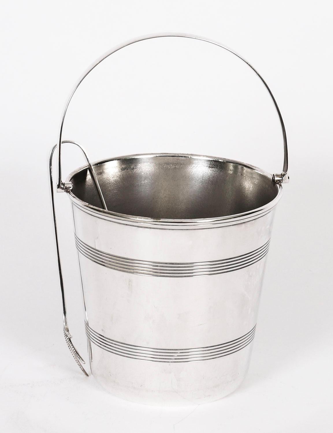 Si tratta di un meraviglioso secchiello per il ghiaccio e pinze in argento edoardiano di Dawson - Unett Silver Plate, datato circa 1900.

L'elegante secchiello con manico rotondo è caratterizzato da fasce scanalate e da una pinza per il ghiaccio con