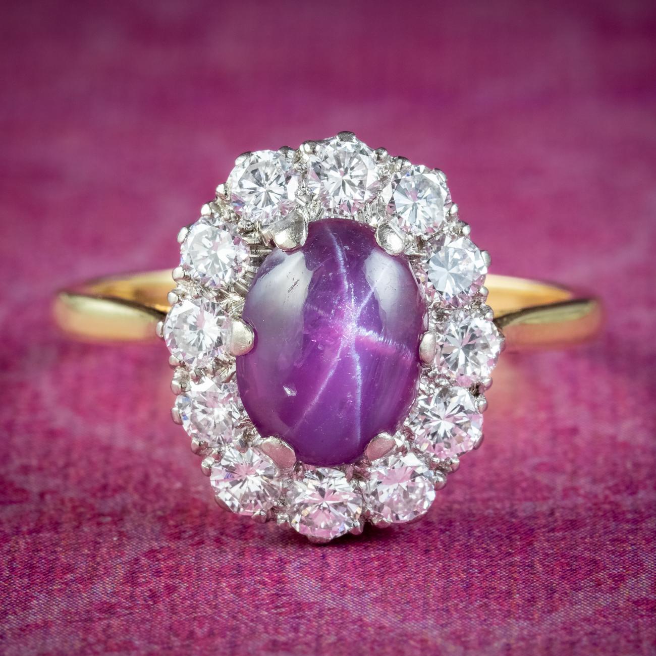  A magnificent antique Edwardian cluster ring crowned with a natural cabochon star ruby weighing approx. 1.8ct, haloed by twelve bright brilliant cut diamonds totalling approx. 1.2ct. 

The ruby has a desirable cherry-pink hue with a ghostly inner