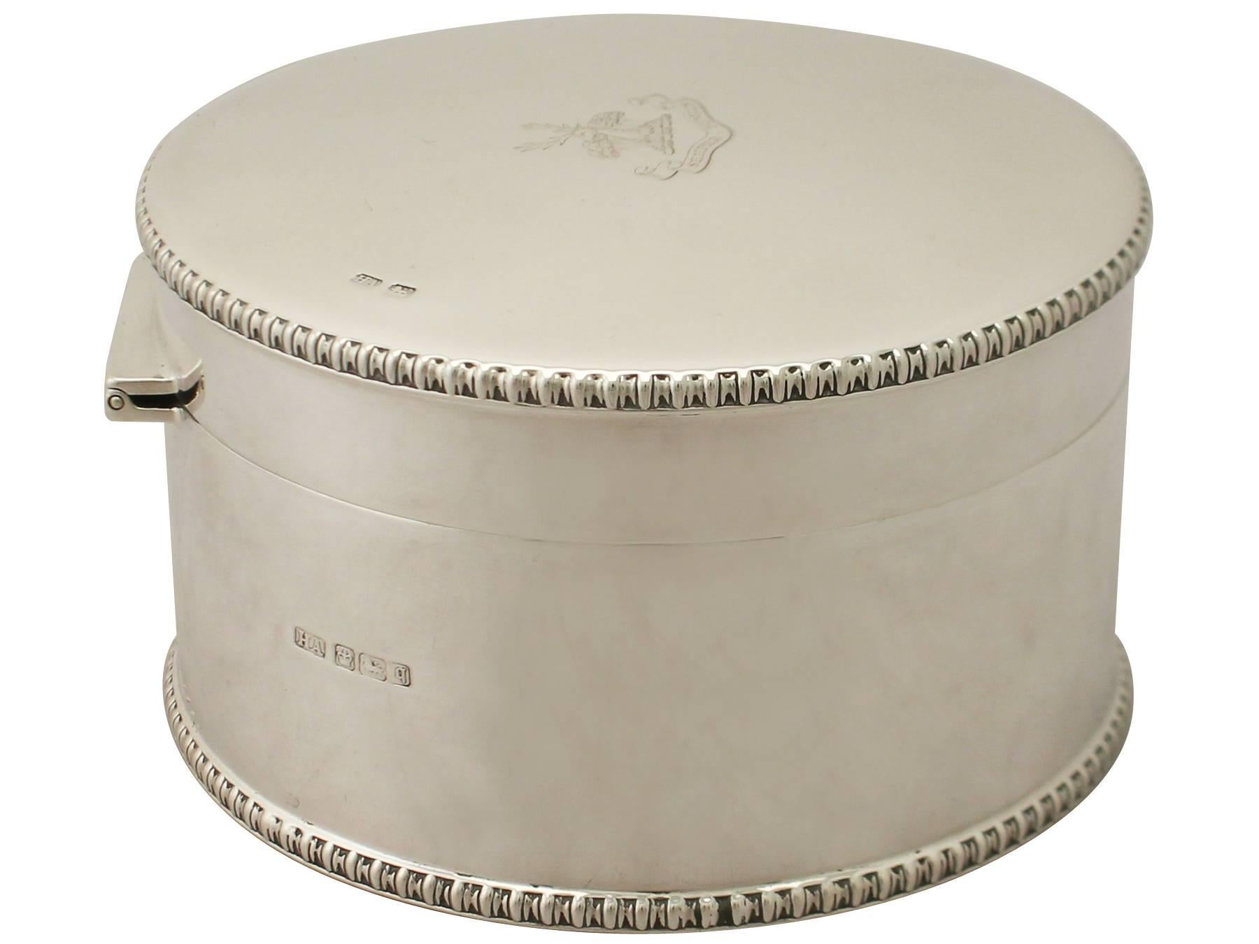 An exceptional, fine and impressive antique Edwardian English sterling silver biscuit box; an addition to our silver teaware collection.

This exceptional antique Edwardian sterling silver biscuit box has a plain circular form.

The surface of