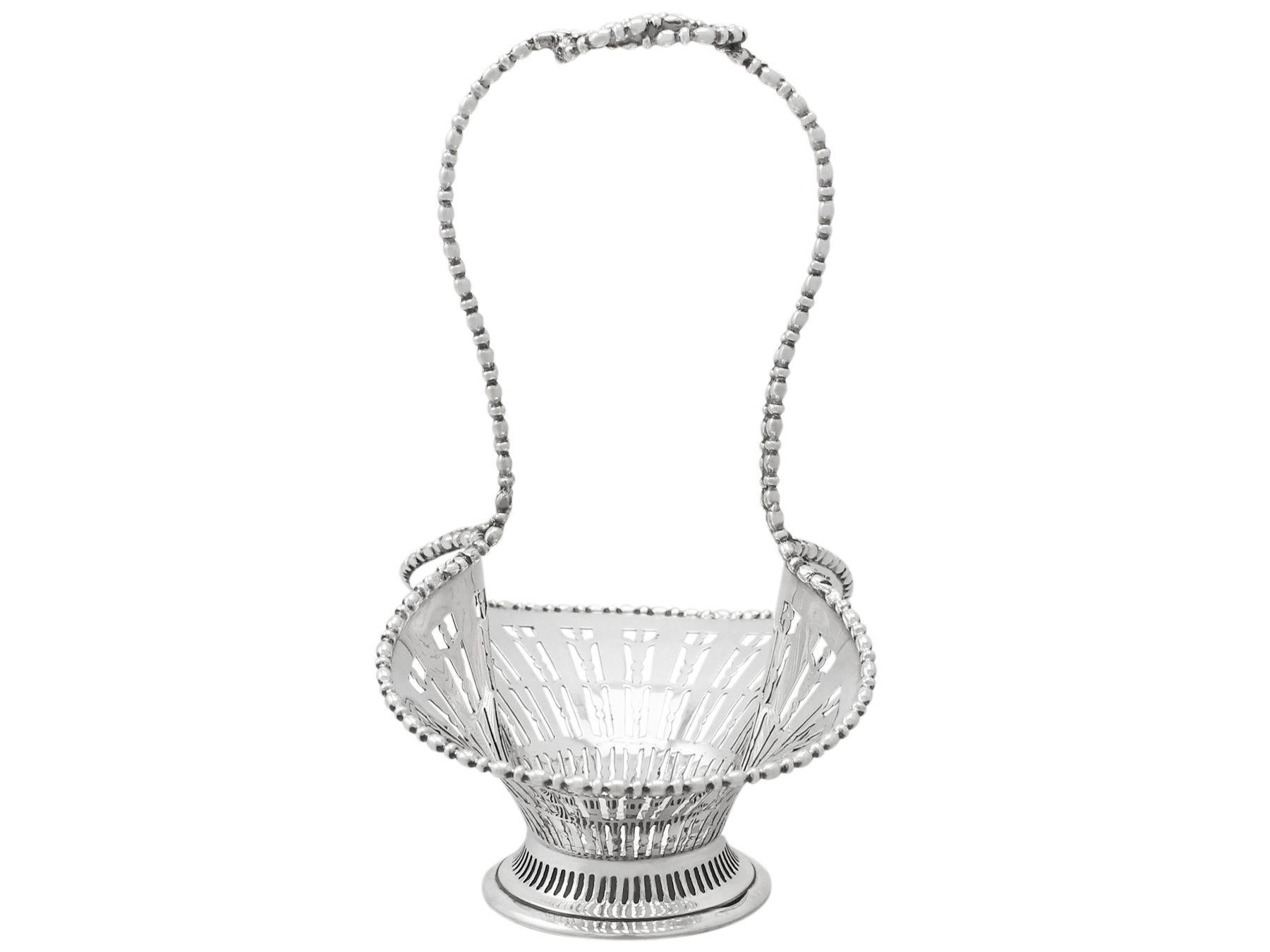 A fine and impressive antique Edwardian English sterling silver bon bon basket; an addition to our diverse ornamental silver collection.

This impressive antique Edwardian sterling silver bon bon basket has a flared waisted form onto a circular