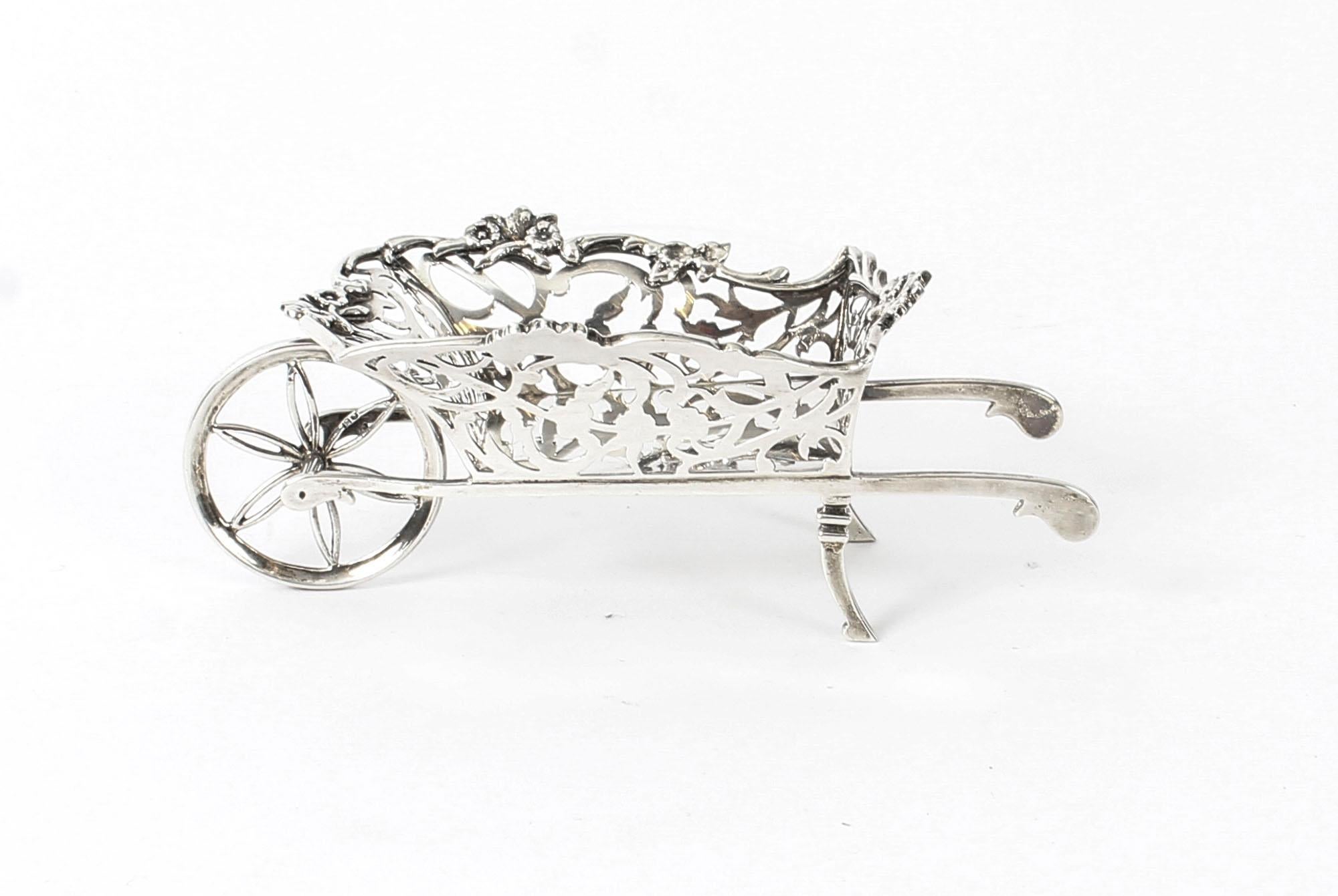 This is an exquisite Edwardian sterling silver bonbon dish with hallmarks for London 1908 and the makers' mark of the renowned silversmith William Comyns.
 
This beautiful bonbon dish is modelled as a lovely wheelbarrow which is superly pierced