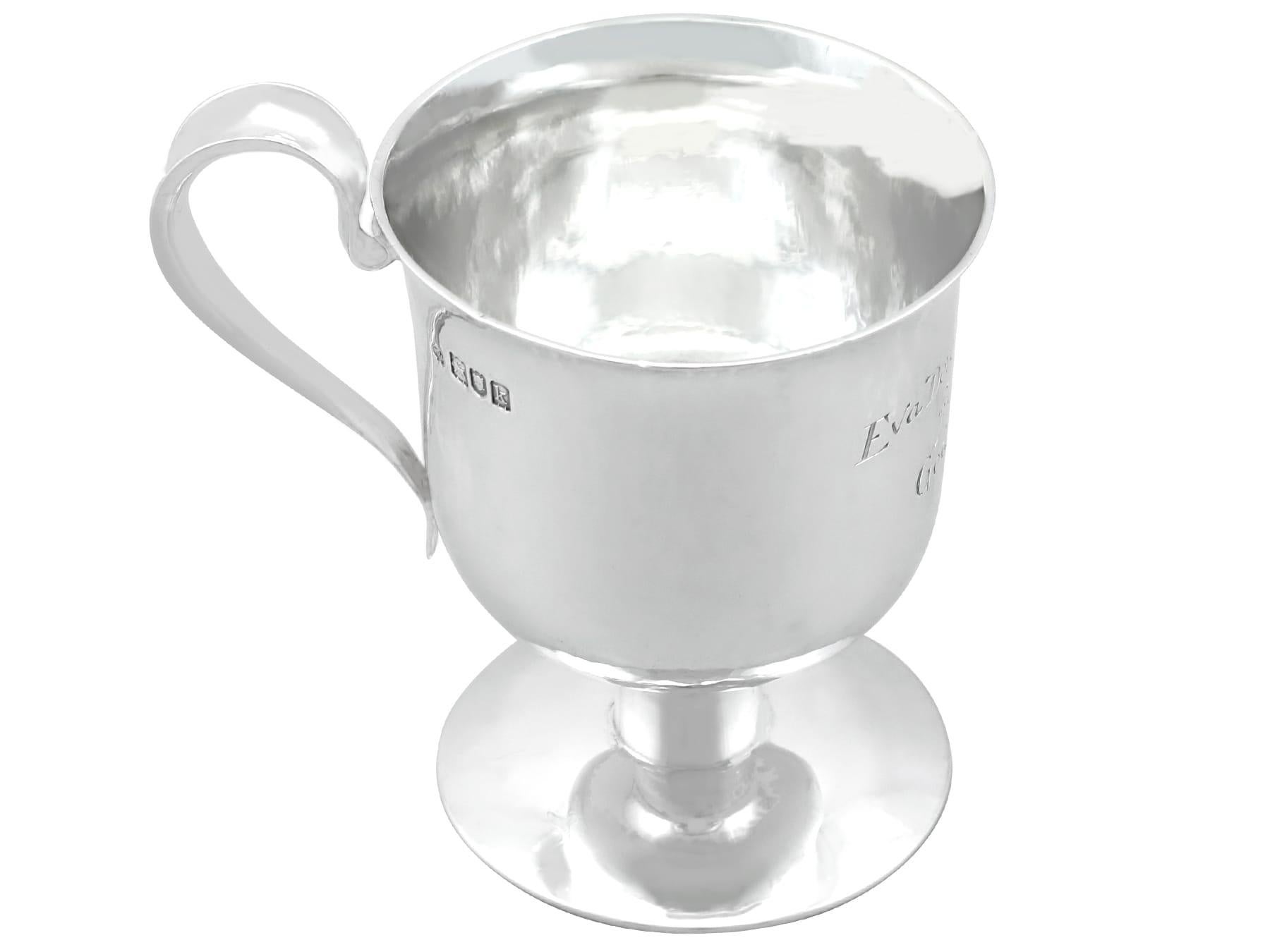 A fine and impressive antique Edwardian English sterling silver christening mug in the Arts & Crafts style; an addition to our wine and drinks related silverware collection.

This fine antique Edwardian sterling silver mug has a plain bell-shaped