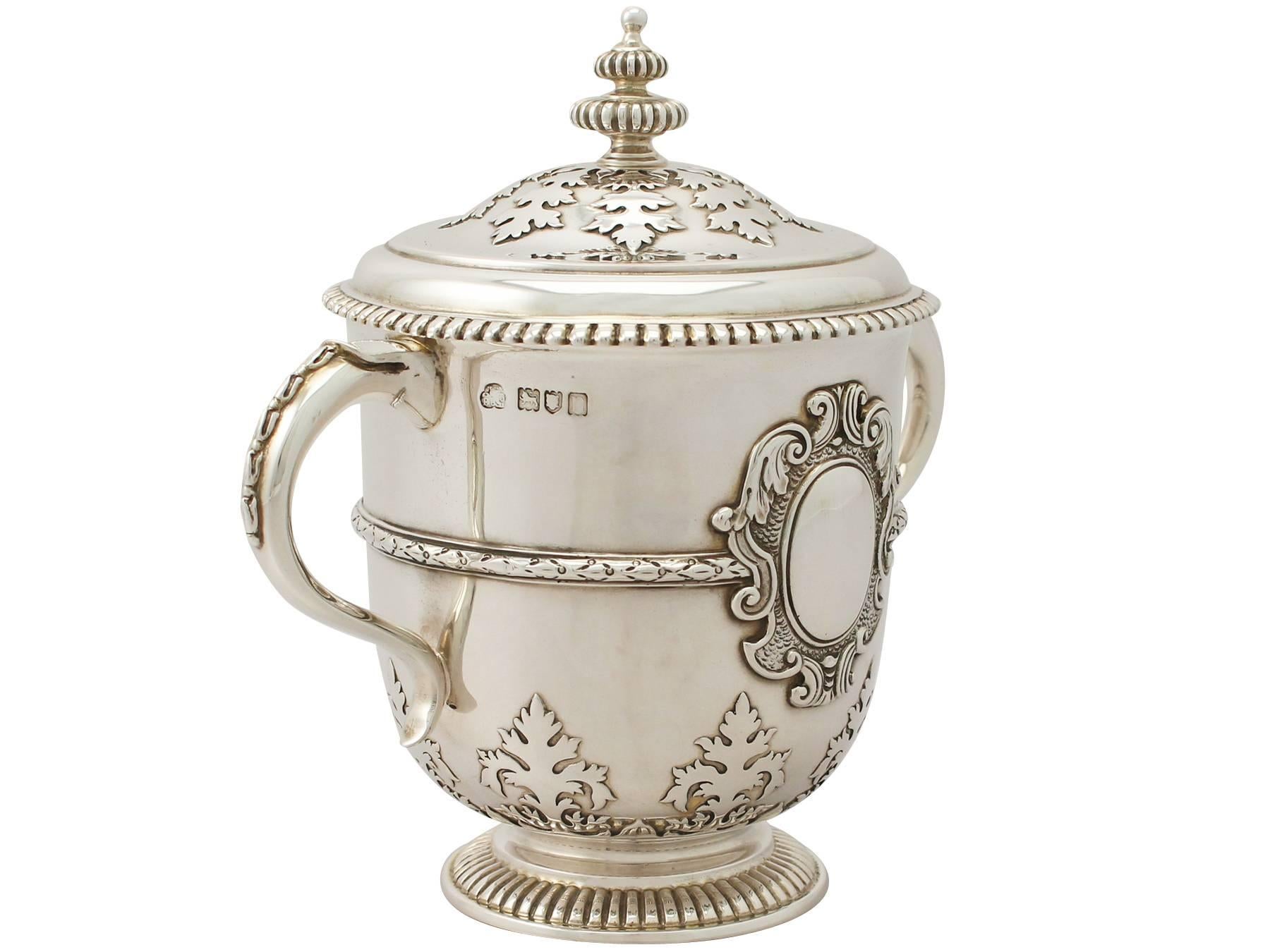 An exceptional, fine and impressive antique Edwardian English sterling silver cup and cover; an addition to our silver presentation collection.

This exceptional antique Edwardian sterling silver cup and cover has a circular bell shaped form onto