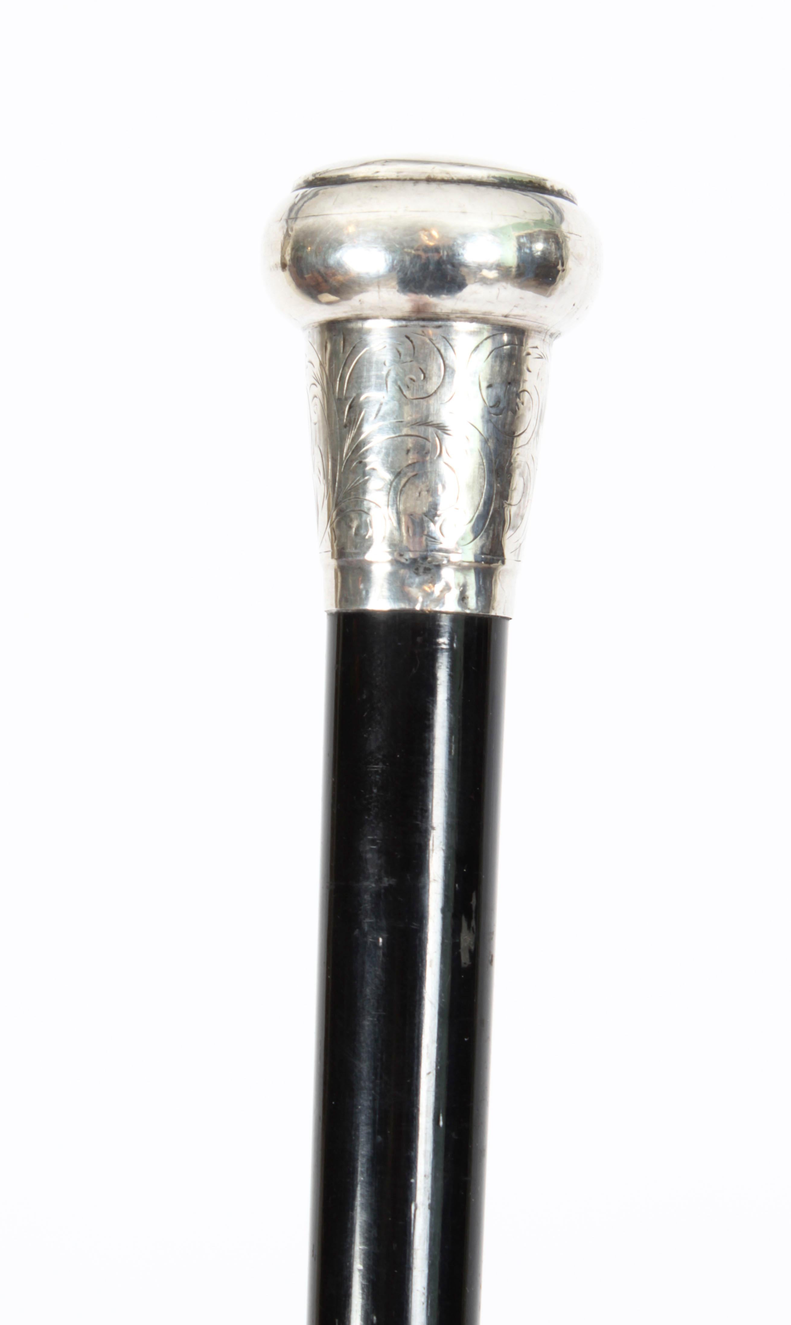 This is a beautiful antique Edwardian sterling silver pommel and ebonised shaft walking stick with hallmarks for London, mae by by Alfred Clarke, dated 1904.
 
This decorative walking cane features an exquisite cast silver pommel with engraved