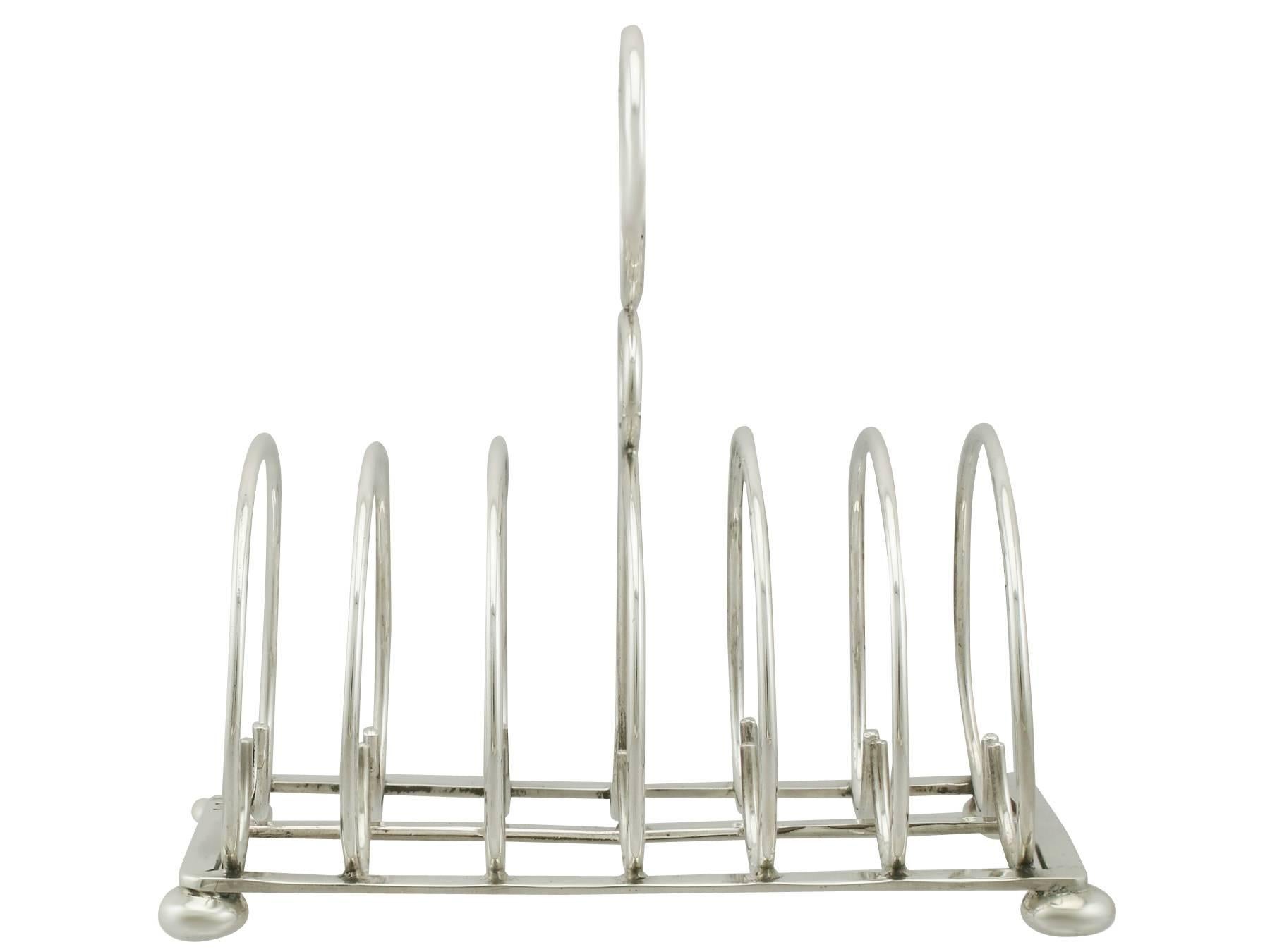 A fine and impressive antique Edwardian English sterling silver toast/letter rack; an addition to our dining silverware collection.

This exceptional antique Edwardian sterling silver toast / letter rack has a rounded form.

This antique silver