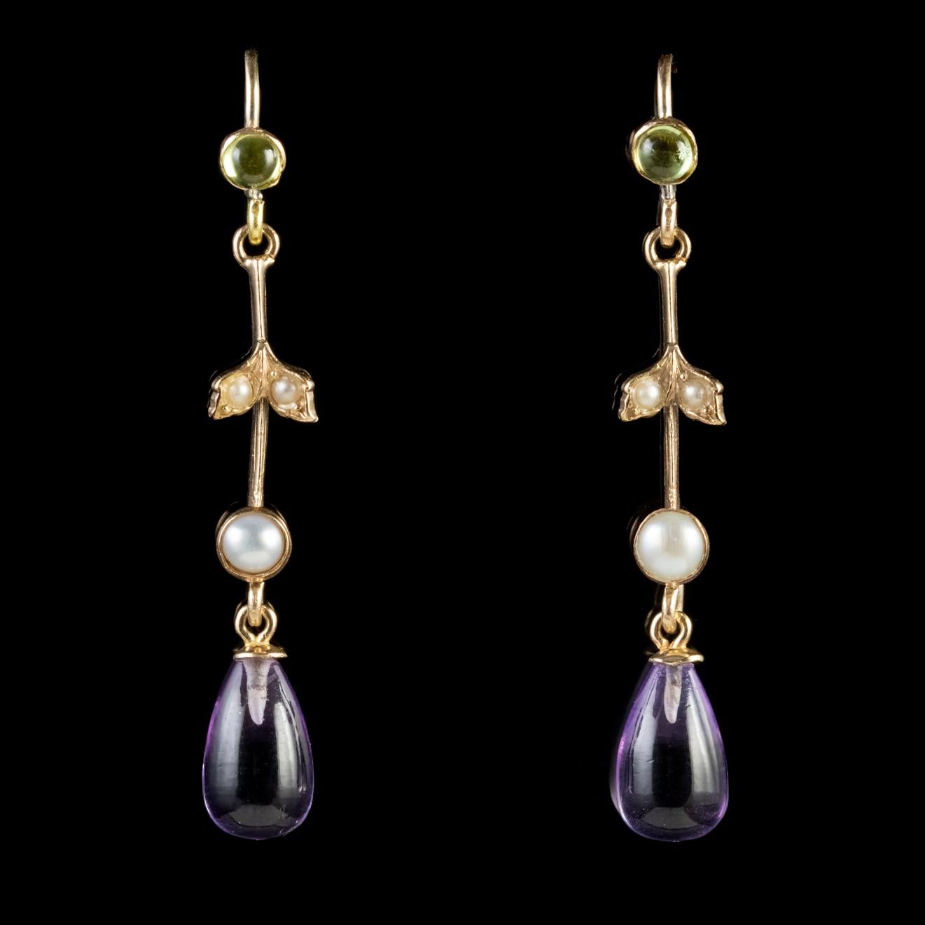 A fabulous pair of Antique Suffragette earrings from the Edwardian era, Circa 1915. Each long, slender earring is crowned with cultured Pearls, a cabochon cut Peridot and a wonderful transparent Amethyst dropper.

Suffragette jewellery was worn to