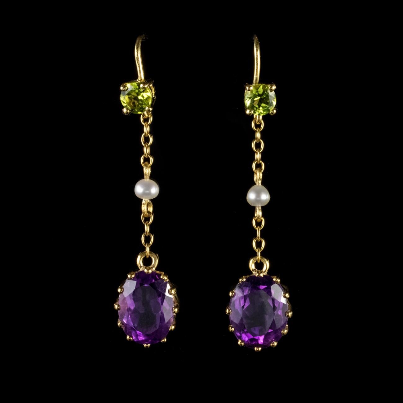 These beautiful Antique Edwardian Suffragette earrings have been modelled in 9ct Yellow Gold. Each earring features an uppermost 0.30ct Peridot which leads down to a Pearl set in the middle of a delicate chain. Finally the chain leads down to a