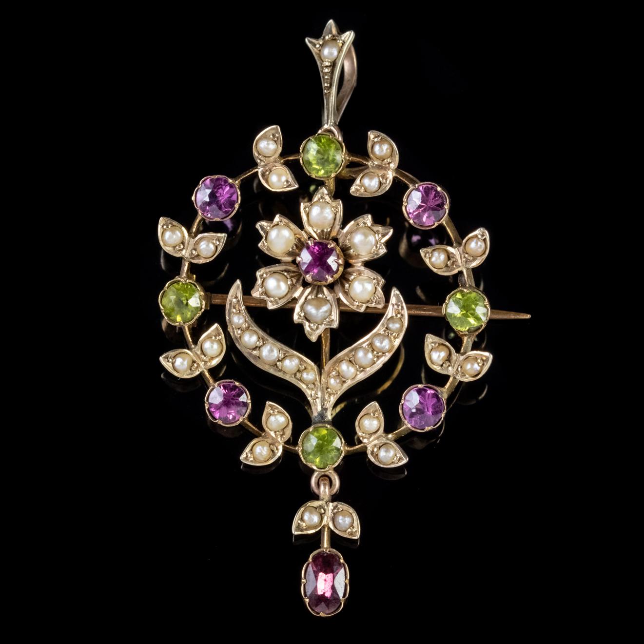 A fabulous Antique Suffragette pendant made Circa 1910. The piece depicts a beautiful wreath encircling a central flower decorated with a colourful array of Peridots, Pearls and Amethysts with a fancy dropper hanging below. 

Suffragettes liked to