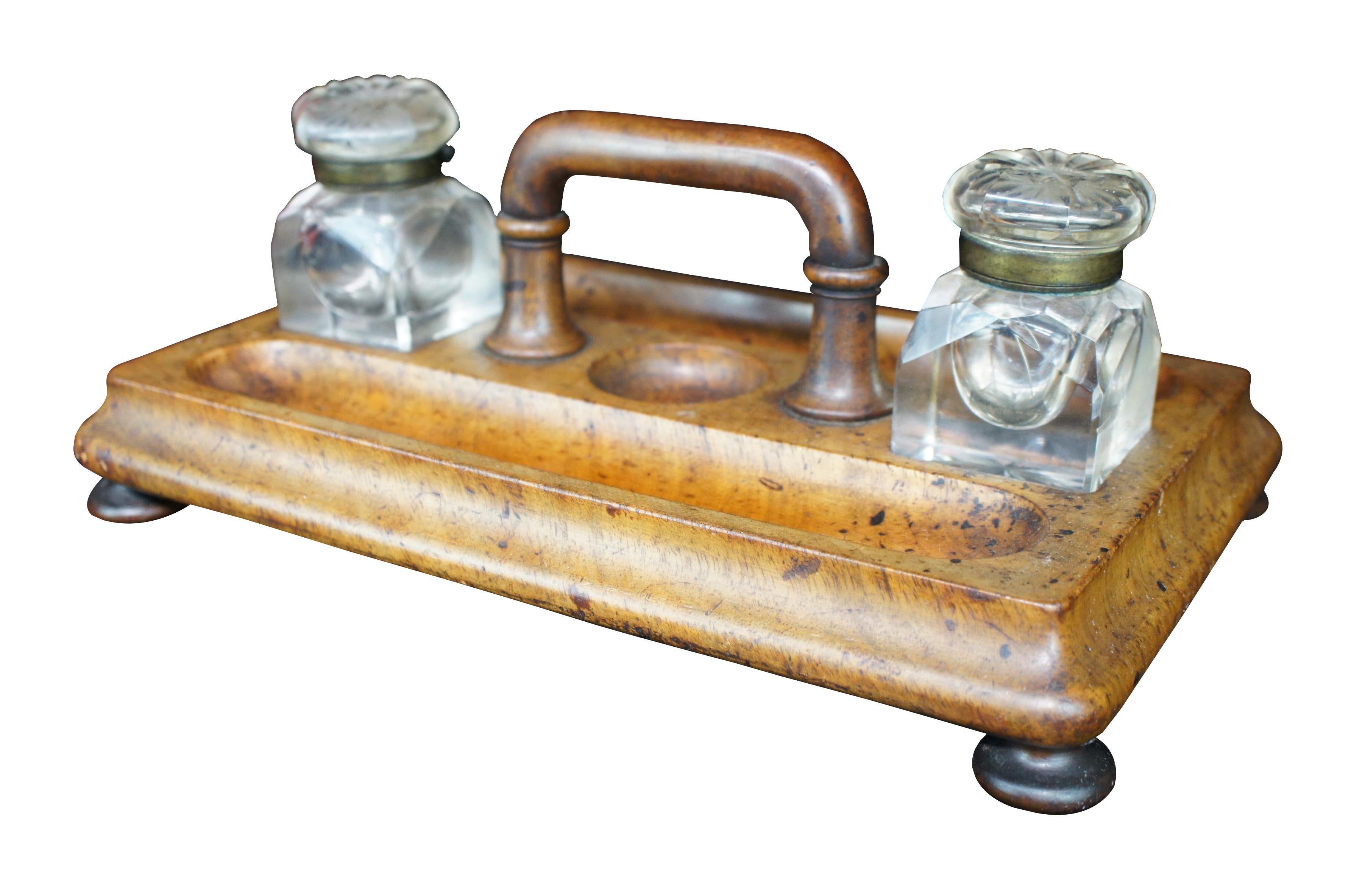 Early 20th century Edwardian Era Ink Stand. Made from walnut with a rectangular form and centrally located handle flanked by two crystal cut inkwells. The beautiful caddy is double sided with trough shaped molded pen holders. The stand is supported