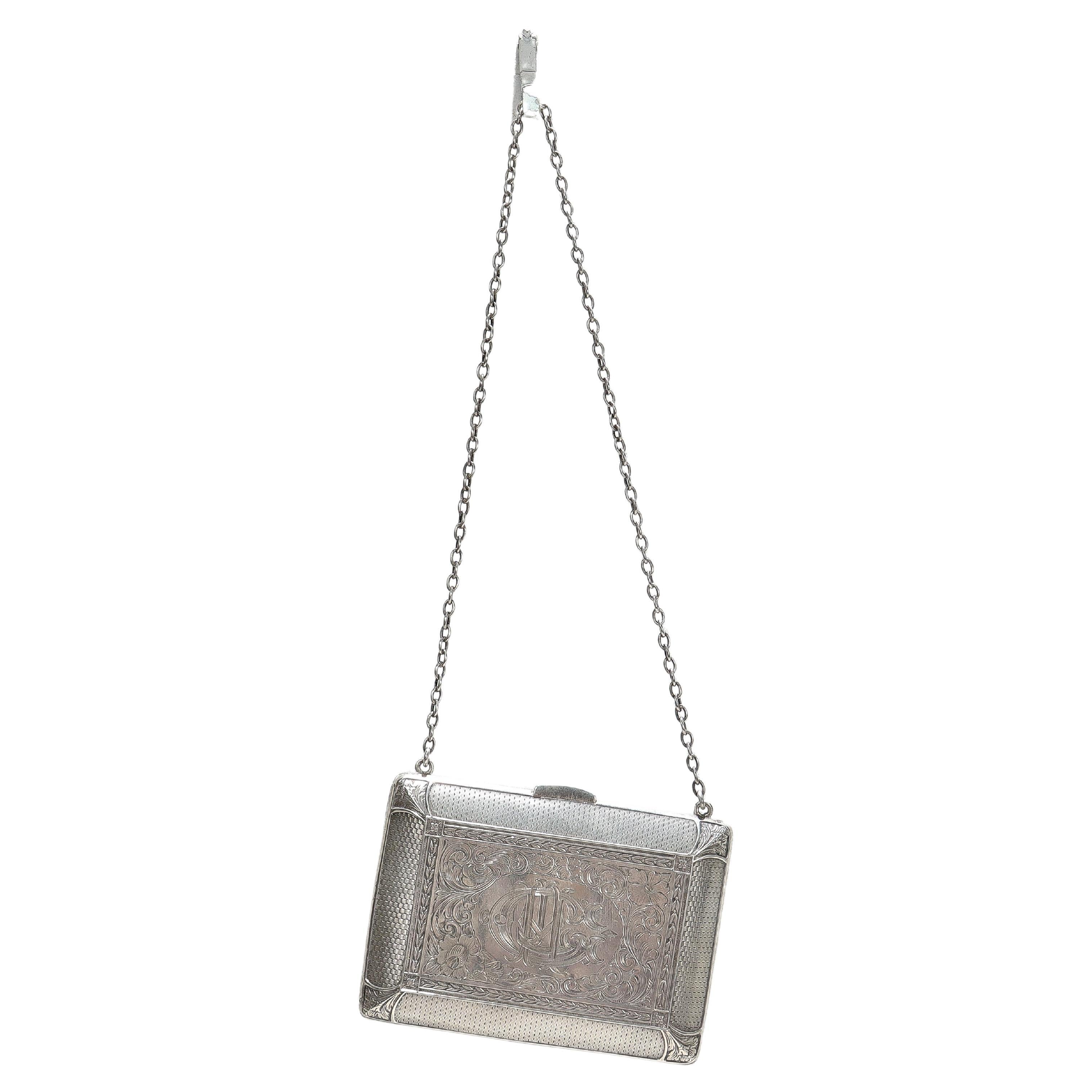 A fine antique Edwardian purse or evening bag.

In sterling silver.

By William B. Kerr & Co.

The purse has a small chain and opens with a button. The interior has two pockets on either side of a central locking pocket. 

Having panels of engraved