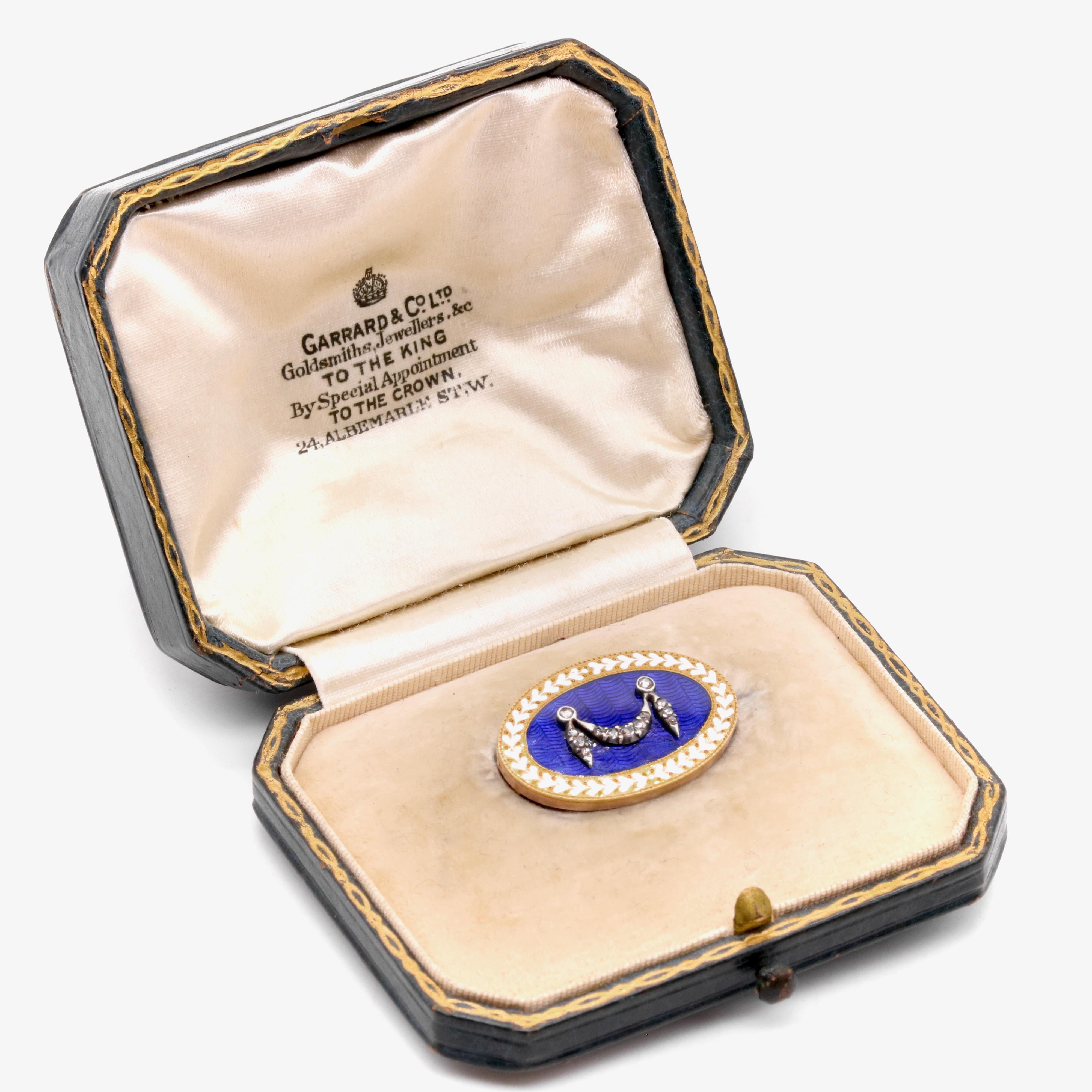 An Edwardian diamond, enamel, silvery, and yellow gold brooch, comprising thirteen rose cut diamonds, set in silver, adorned with blue and white enamel, set in 18 karat yellow gold, backed in 9 karat yellow gold, with 9 karat yellow gold pin and