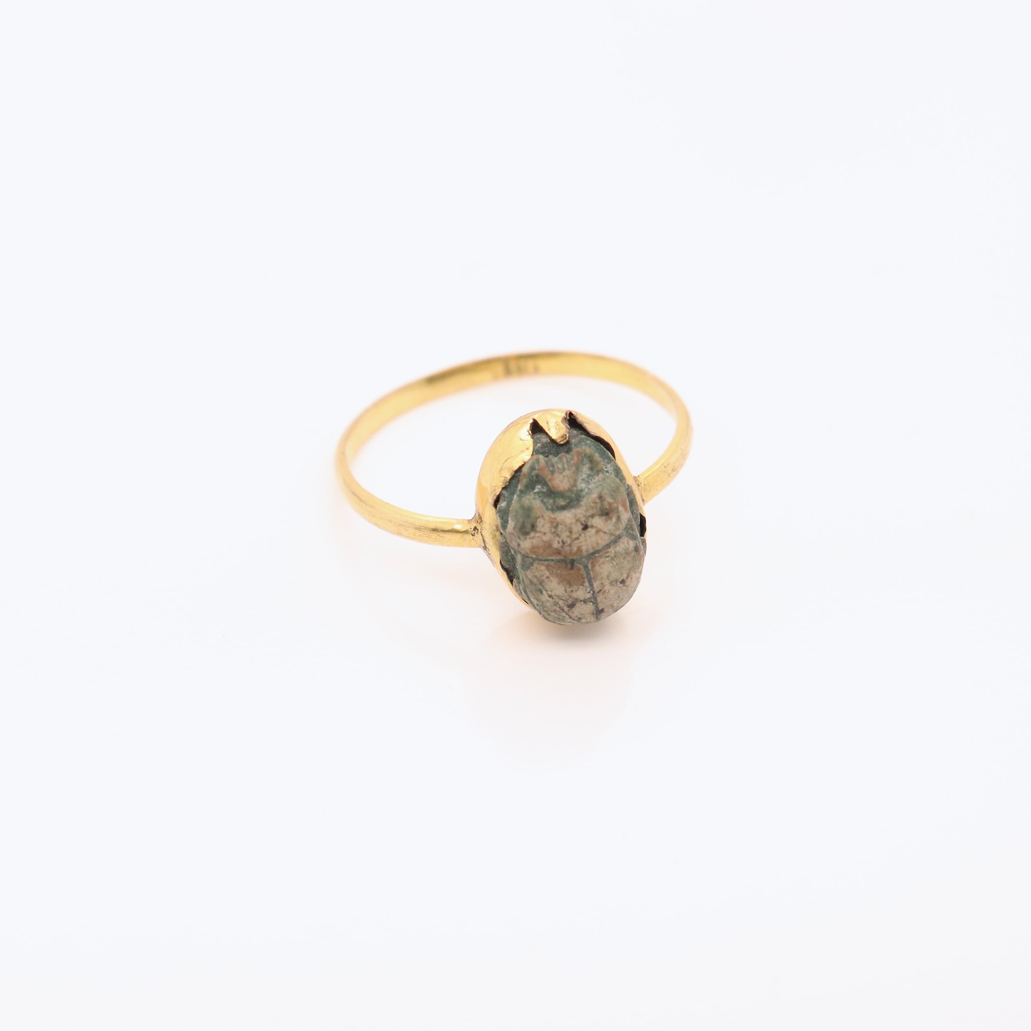 A fine antique Egyptian gold & faience pottery ring.

With an old tag attached identifying the scarab as ancient.

Set in a rudimentary bezel setting and mounted on a gold band that tests at 10k.

Simply a wonderful piece of antique