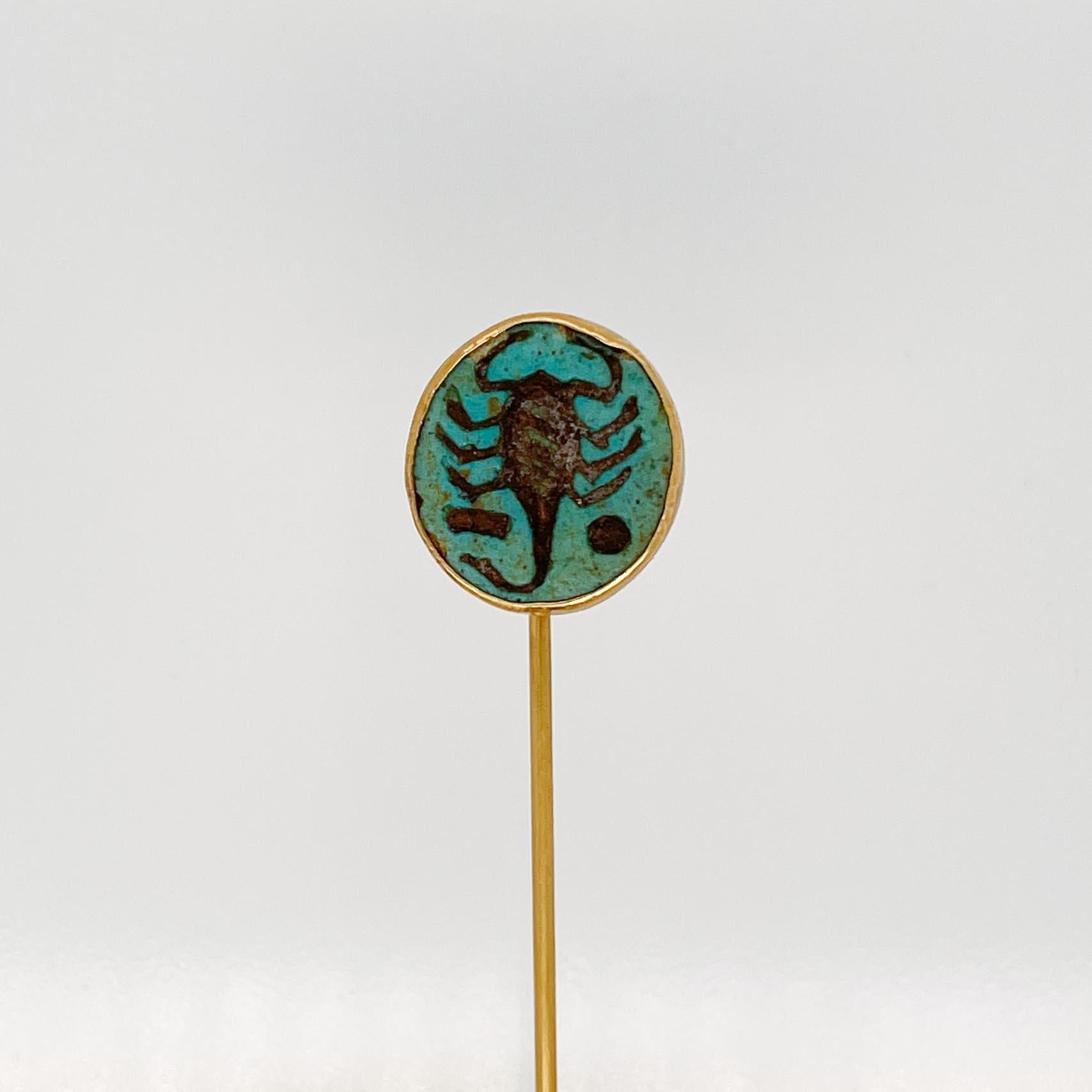 A fine Art Nouveau period or Egyptian Revival stick pin.

In 14 karat yellow gold.

Set with an Egyptian Faience cabochon with the image of a scorpion. (Possibly an ancient Egyptian scarab.)

Simply a wonderful Revival piece! 

Date:
ca.
