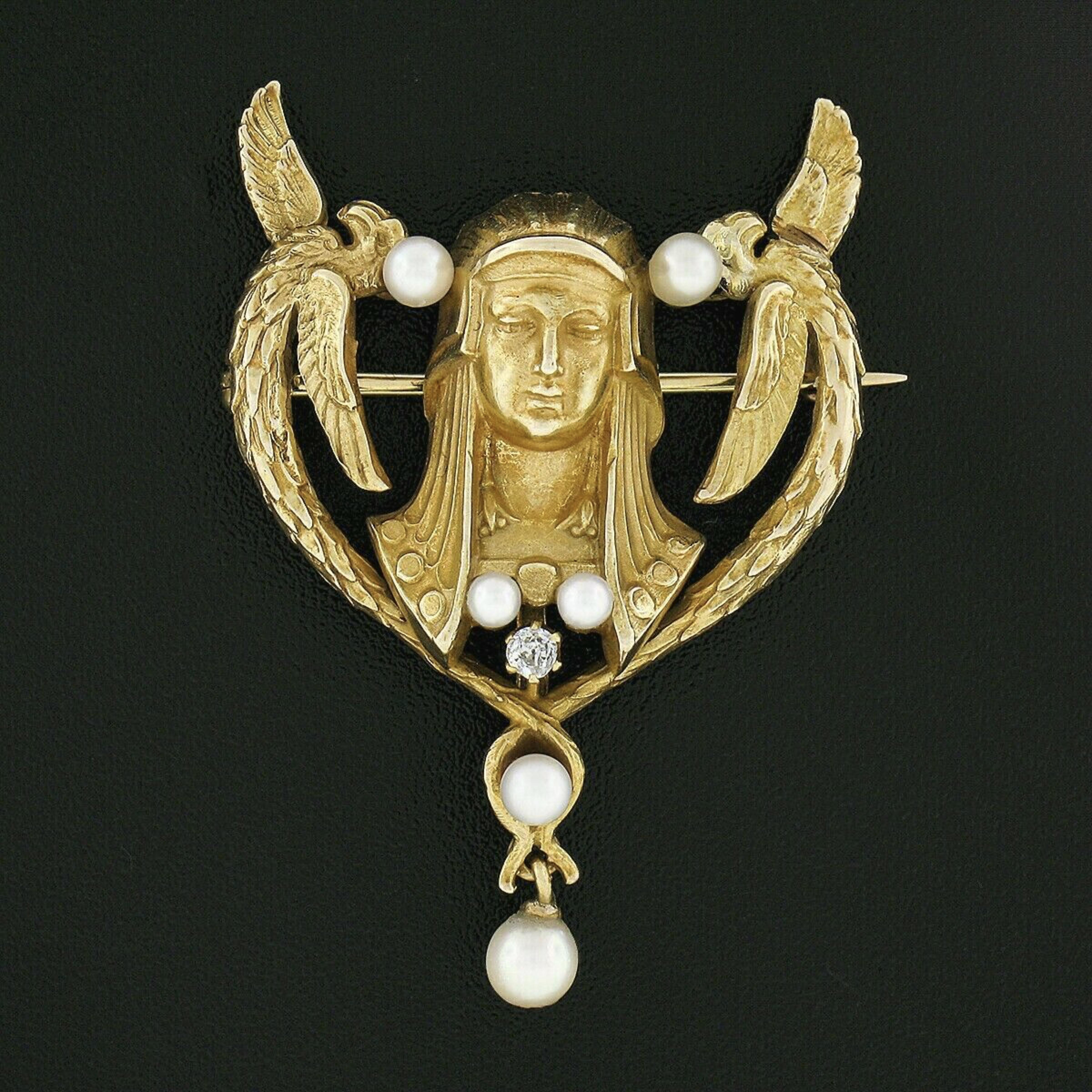 This outstanding antique brooch was crafted during the art nouveau era from solid 14k yellow gold and features a beautiful Egyptian revival design set with a fine quality natural diamond and lovely cultured pearls throughout. The brooch displays an