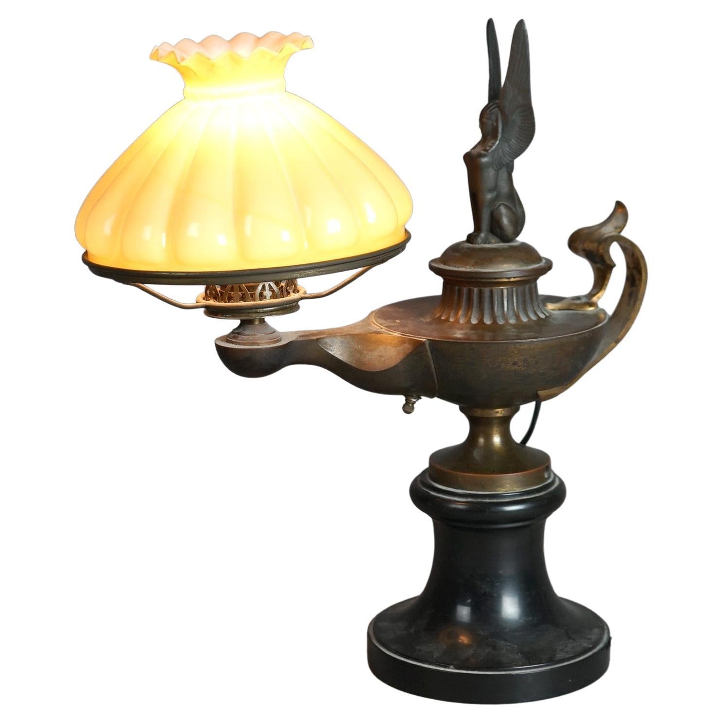 Antike ägyptische Wiedergeburt Aladdin Form Figural Phoenix Schreibtischlampe mit Cased Glass Butterscotch Shade, Anfang 20.

Maße - 15,5 