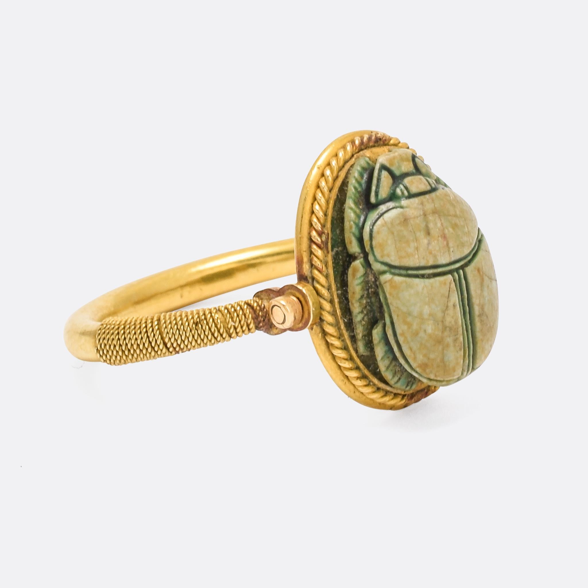A particularly fine example of a Victorian Egyptian Revival Scarab Spinner ring, dating from the 1870s. The faience scarab is delicately carved, featuring a lotus and barley motif to the reverse. The head spins freely, and the ring features wound
