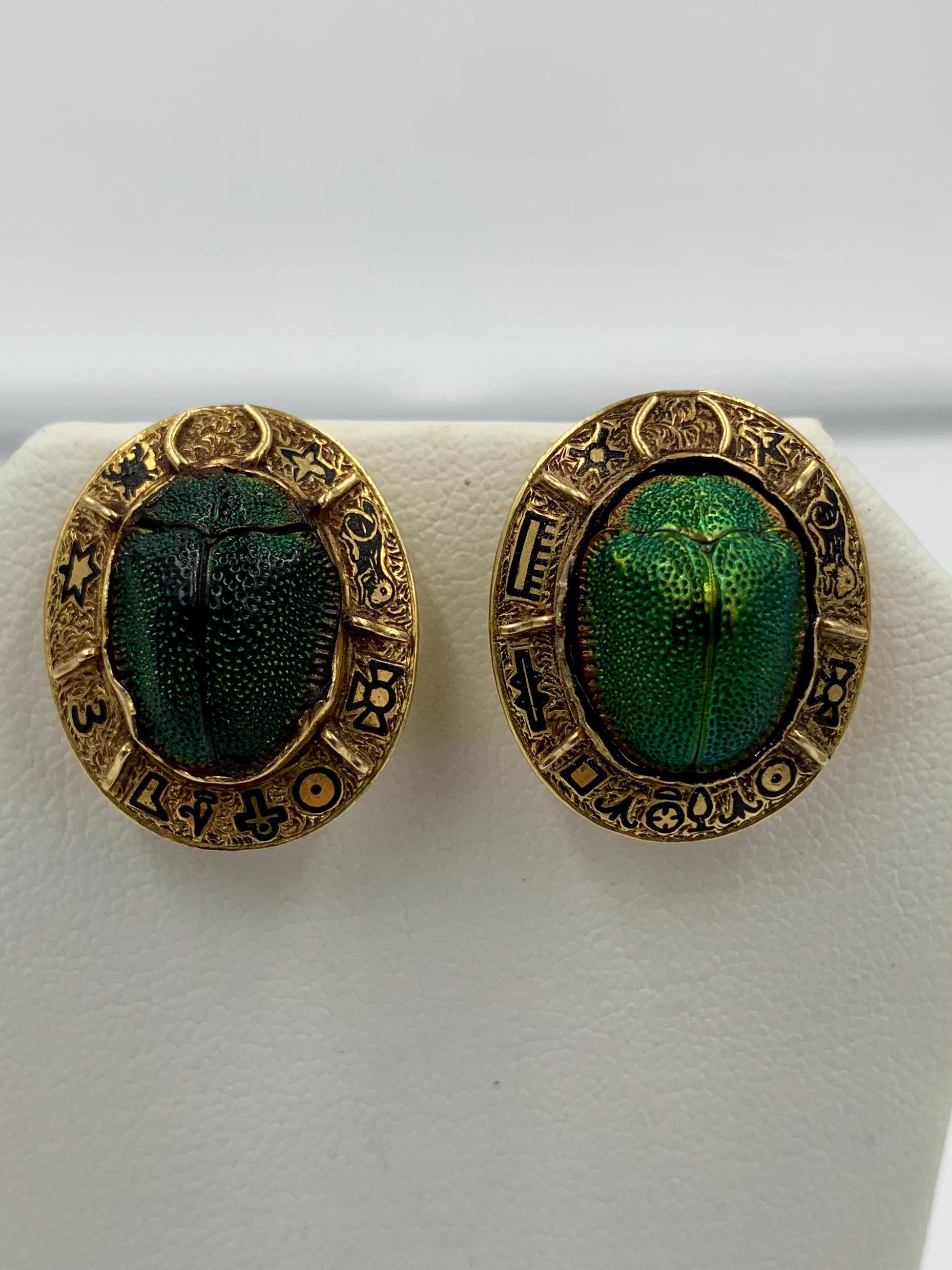 Belle Epoque - Art Deco Egyptian Revival masterpieces.  The earrings with iridescent green natural Scarab insects in the center surrounded by a stunning 14-16 Karat Gold border with Egyptian Hieroglyphic inspired motifs in black enamel.  The jewels