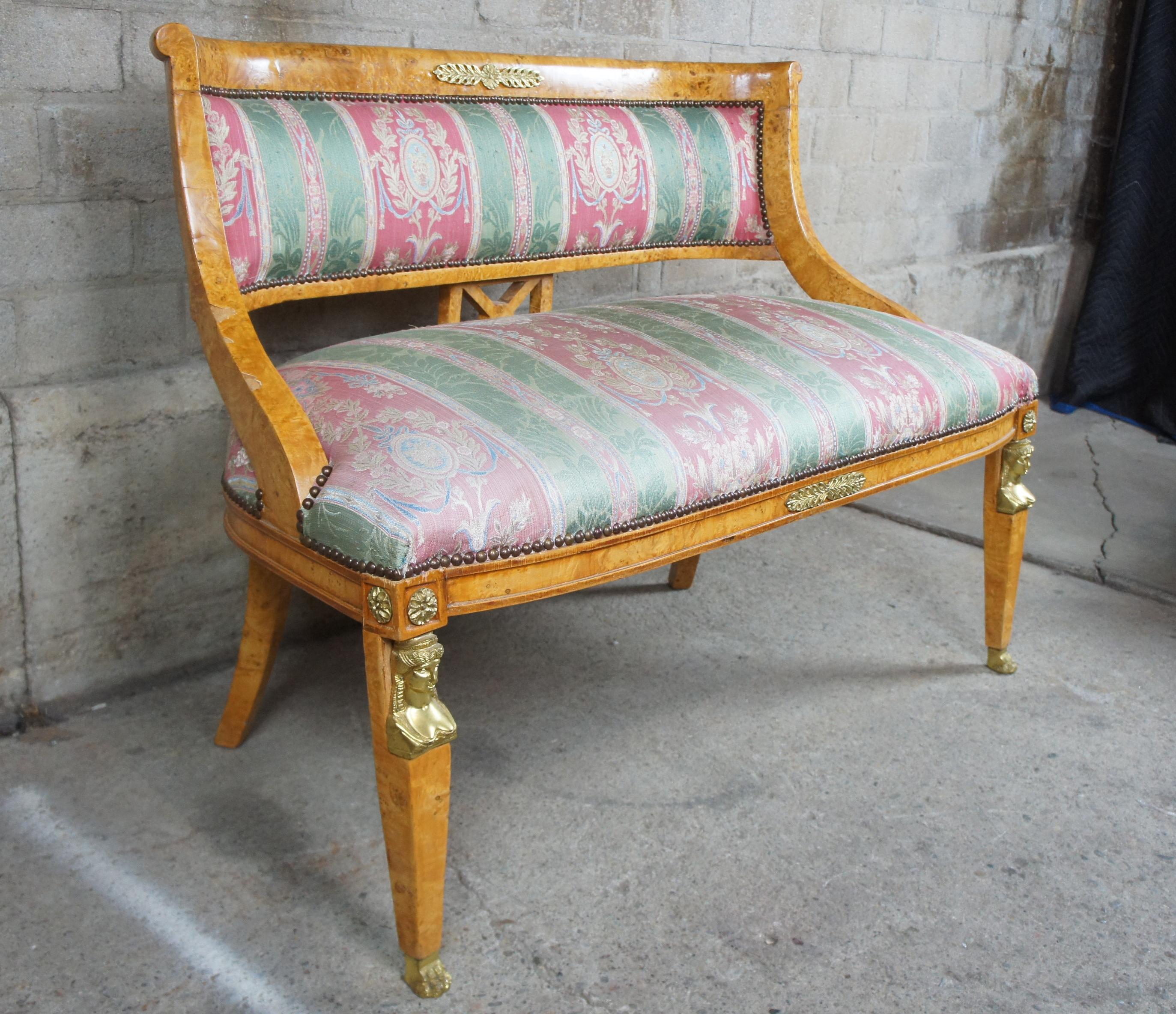 Monumental early 20th century parlor settee. A neoclassical and Egyptian revival inspired design. Features a curved rail with unique X-back between contoured arms leading to regal striped upholstery. The chairs are supported by square tapered front