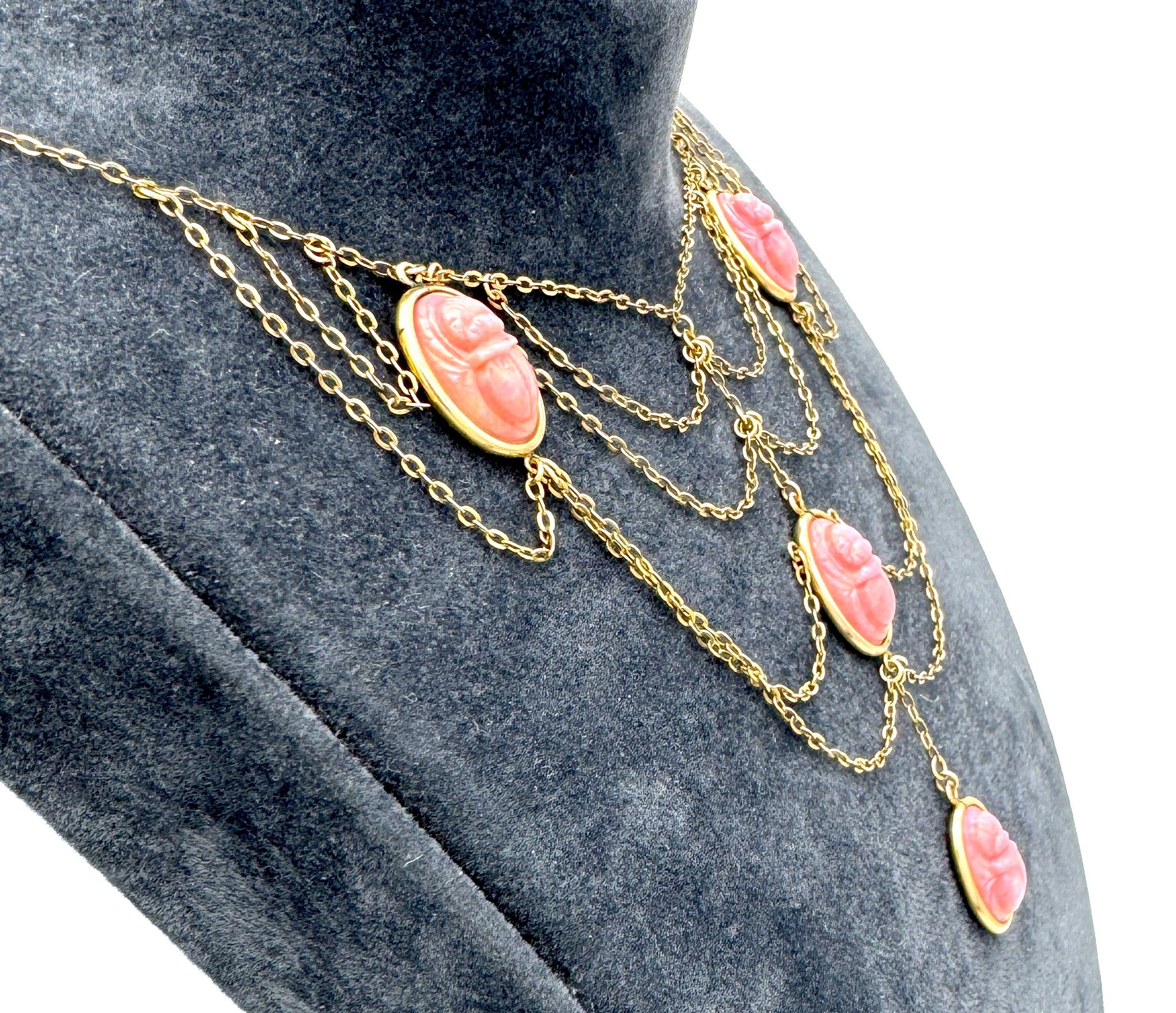 This elegant Egyptian Revival necklace was created during the Belle Époque, 1885-1905 ca. The necklace is composed of four cast pink glass scarabs with impressed fantasy inscriptions on the reverse. Three of the scarabs have strong white inclusions