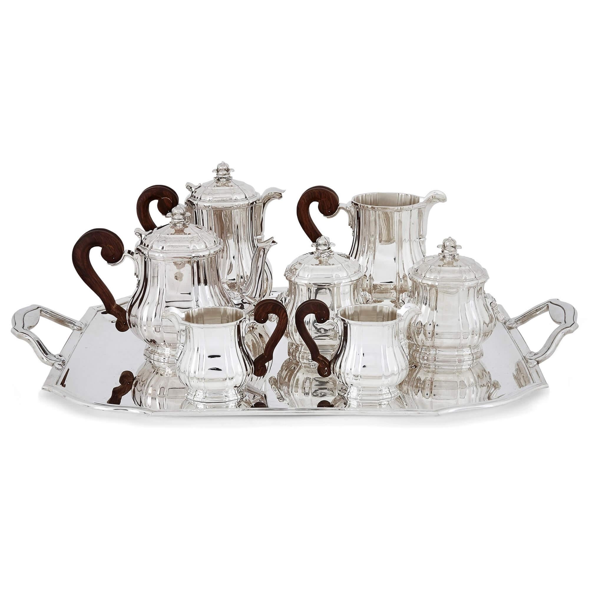 Antique eight-piece silver coffee and tea set by Tétard
French, early 20th century
Tray: Height 6cm, width 73.5cm, depth 46.5cm
Water jug: Height 19cm, width 21cm, depth 11cm

This elegant tea and coffee set features eight pieces: a teapot, a