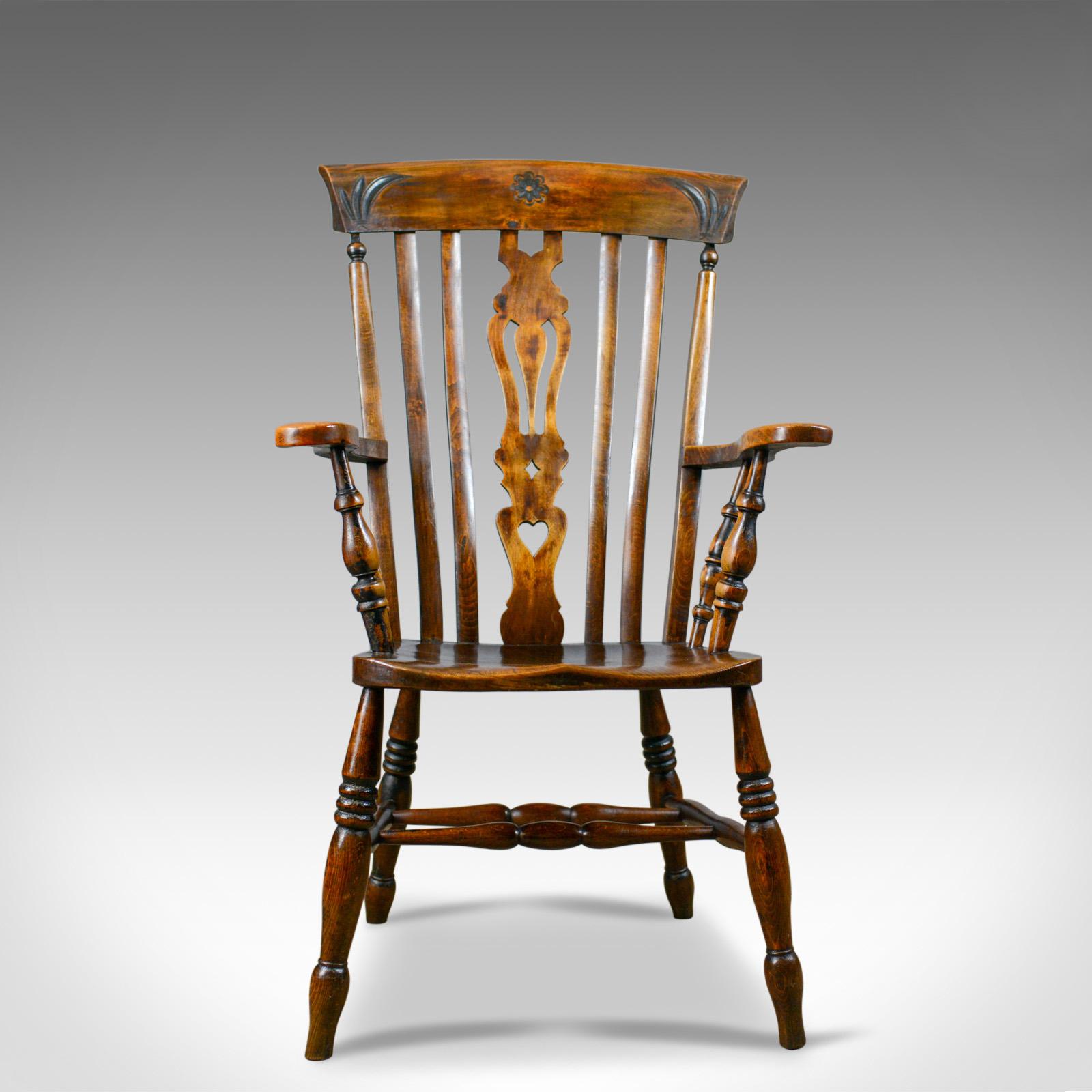 This is an antique elbow chair. An Edwardian, country kitchen, Windsor, lath back, armchair in beech, dating to the early 20th century, circa 1910.

Super chair in fine order throughout
Classic, lath back flanking pierced splat
Good color and a