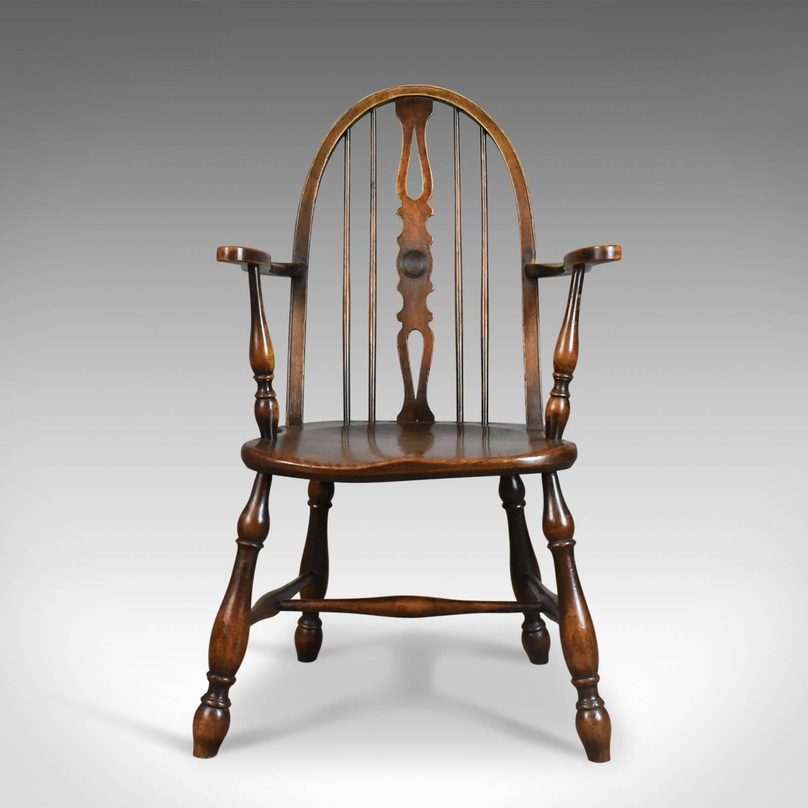 This is an antique elbow chair, an English, Victorian bow-back Windsor chair in beech and elm dating to circa 1890.

Appealing color and a desirable aged patina
Grain interest to the thick elm, saddle seat slab
Gothic overtones to the arched bow