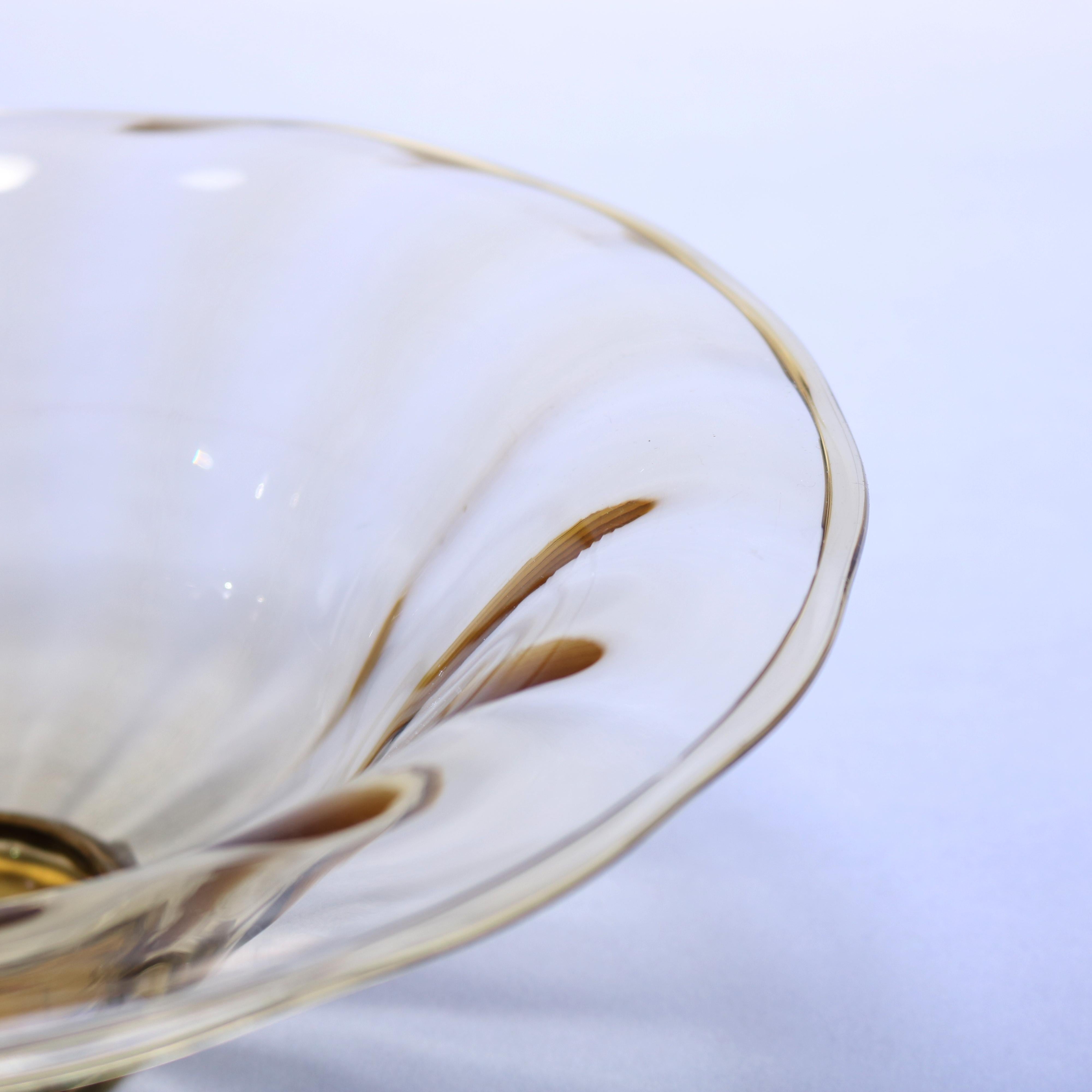 An antique elegant glass center bowl offers flared form, vessel with wide ribbing in amber and seated on round foot, circa 1920

Measures- 4.25