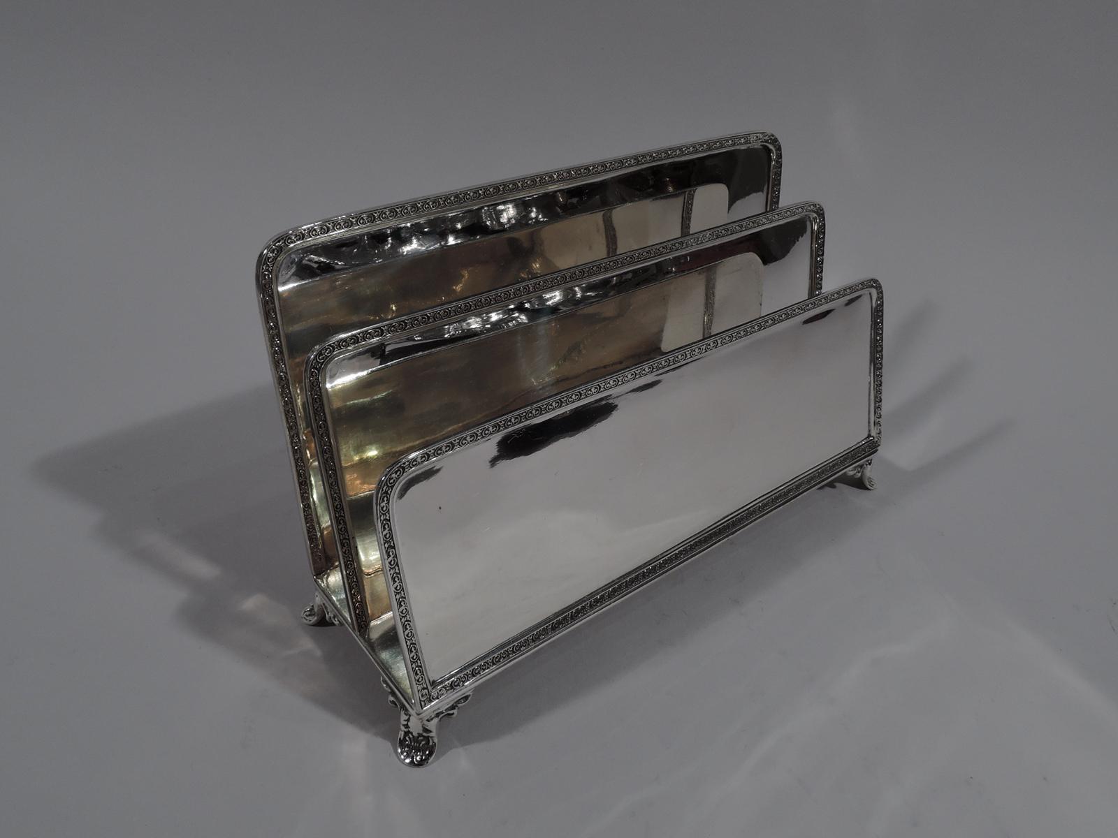 Elegant Edwardian sterling silver letter rack. Made by Graff, Washbourne & Dunn in New York, circa 1910. Three graduated rectangular panels with curved corners mounted to rectangular base with four leaf supports. Raised ornamental borders. Fully