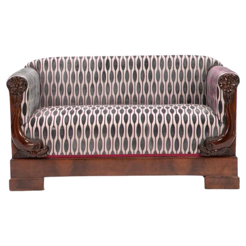 Elegant small Biedermeier sofa in mahogany with fine details in the shape of dolphins on the front.

The sofa is upholstered in Romo-fabric.

Denmark c. 1820-1830. 