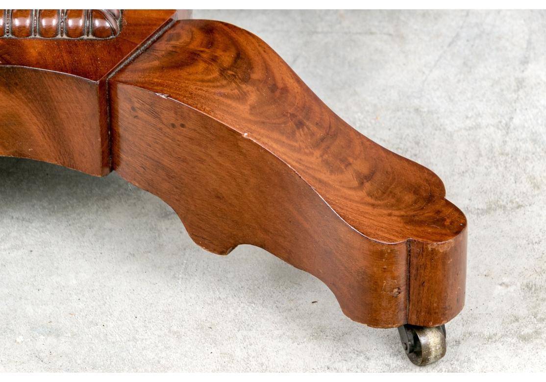 A charming flip top table with a scalloped top with half columns and a carved beaded front and side edges. Raised on an elegant lyre form support mounted on a shaped base with carved band and four shaped legs on casters. 

Dimensions: 35 1/2
