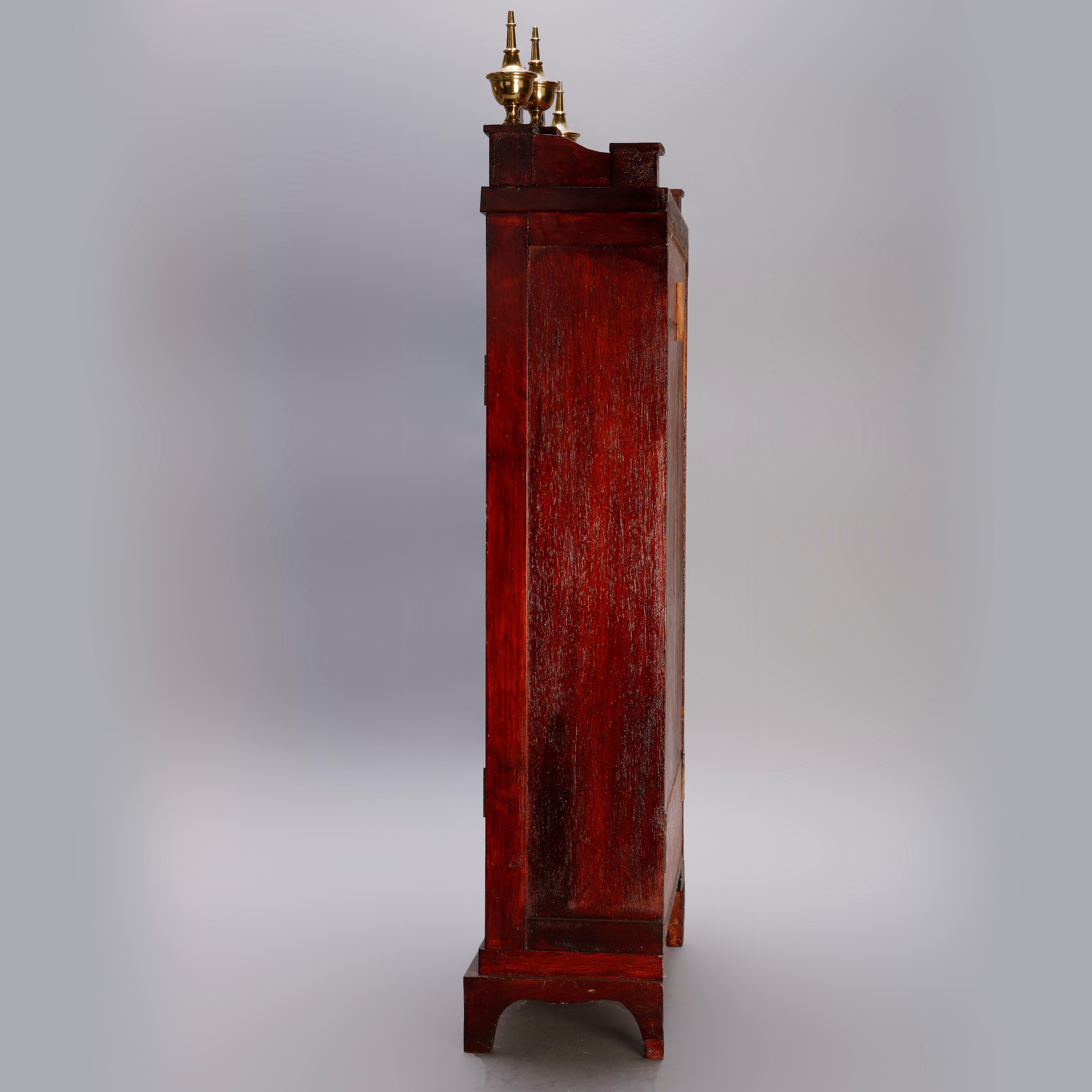 An antique Eli Terry School Pillar & Scroll mantel clock offers mahogany case with broken arch crest having central and flanking finials, face with Roman numerals and lower mirror. Unknown working order, 20th century

Measures: 31.68