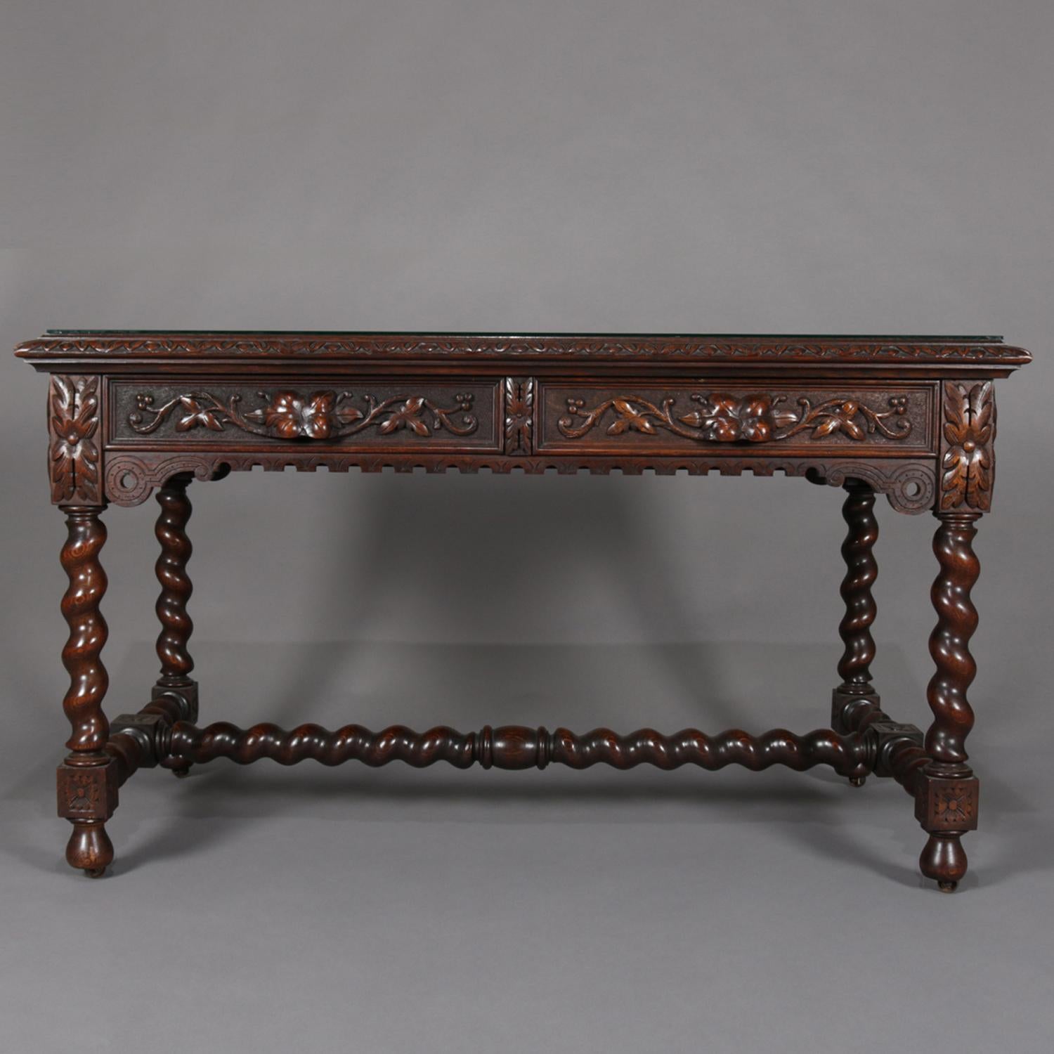 Antique English Elizabethan style mahogany partner's desk features beveled top with protective glass over heavily carved foliate base with one functioning drawer and one faux drawer on opposing sides and raised on barley twist legs joined by H-form