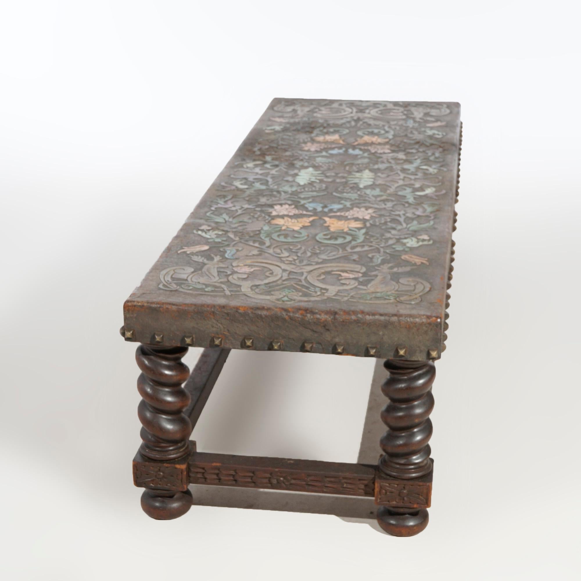 An antique English Elizabethan low bench offers tooled leather top with flower pattern over oak base having rope twist legs, c1910

Measures- 16.5'' H x 64'' W x 21.25'' D.

*Ask about DISCOUNTED DELIVERY rates within 1,500 miles of NY*
