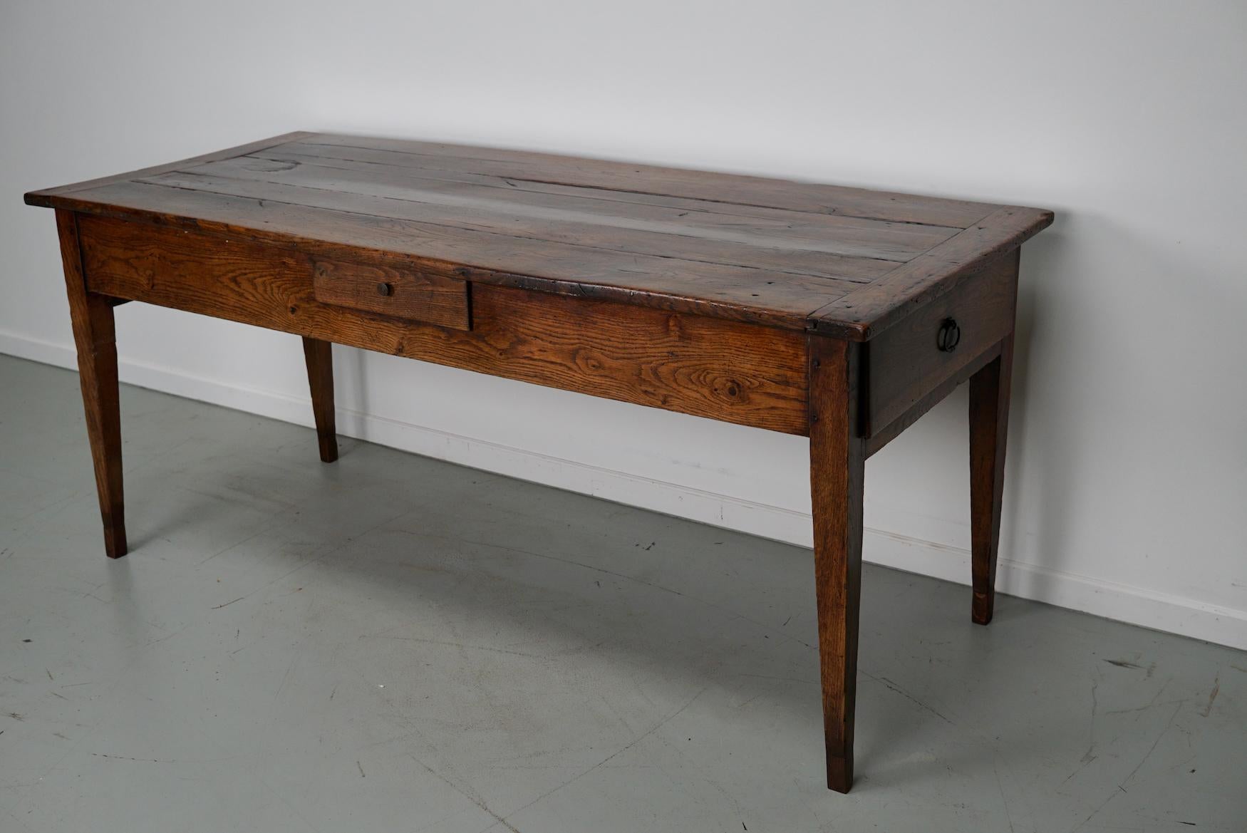 This French farmhouse table was made in the 19th century in France. It retained a very nice rich patina over the years with lot's of old marks and repairs. The leg room / knee height is 60 cm. It has three functional drawers.