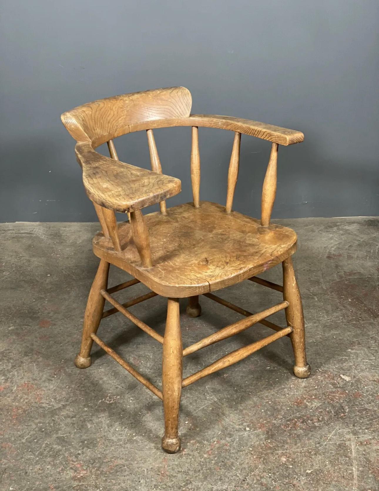 A rare chair dating to the early part of the 20th century. We think the chair was a teachers chair with the oversized arm acting as a bookrest. Made from a rich cut of elm the chair has a deep rich grain.  In good solid condition with some age