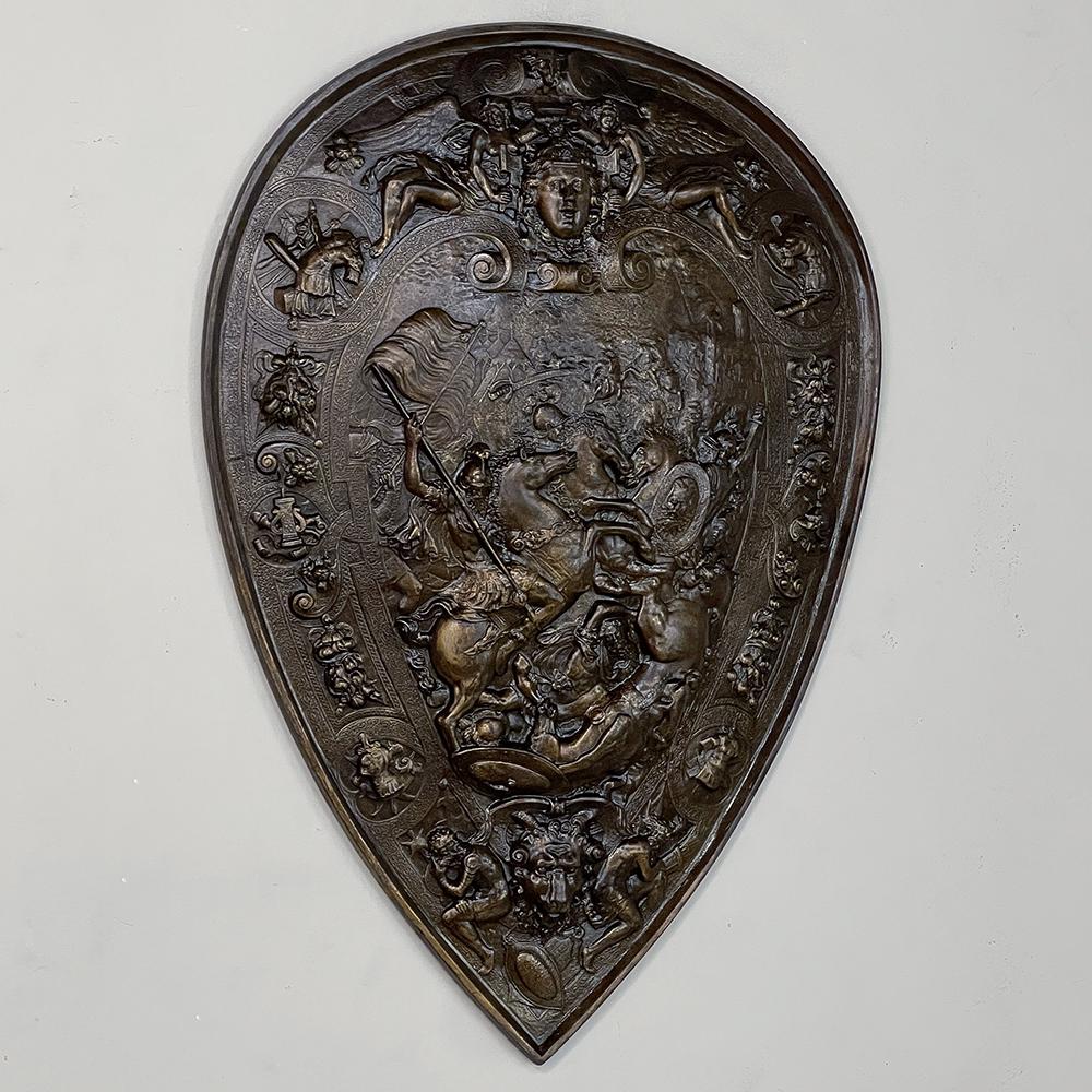 Antique Embossed brass decorative wall shield is a wonderful expression of historical conflict, martial arts, overseen by Mars, the God of War. Fully embossed, it has been finished in a dark patina for a timeless effect. Note the intricate detail