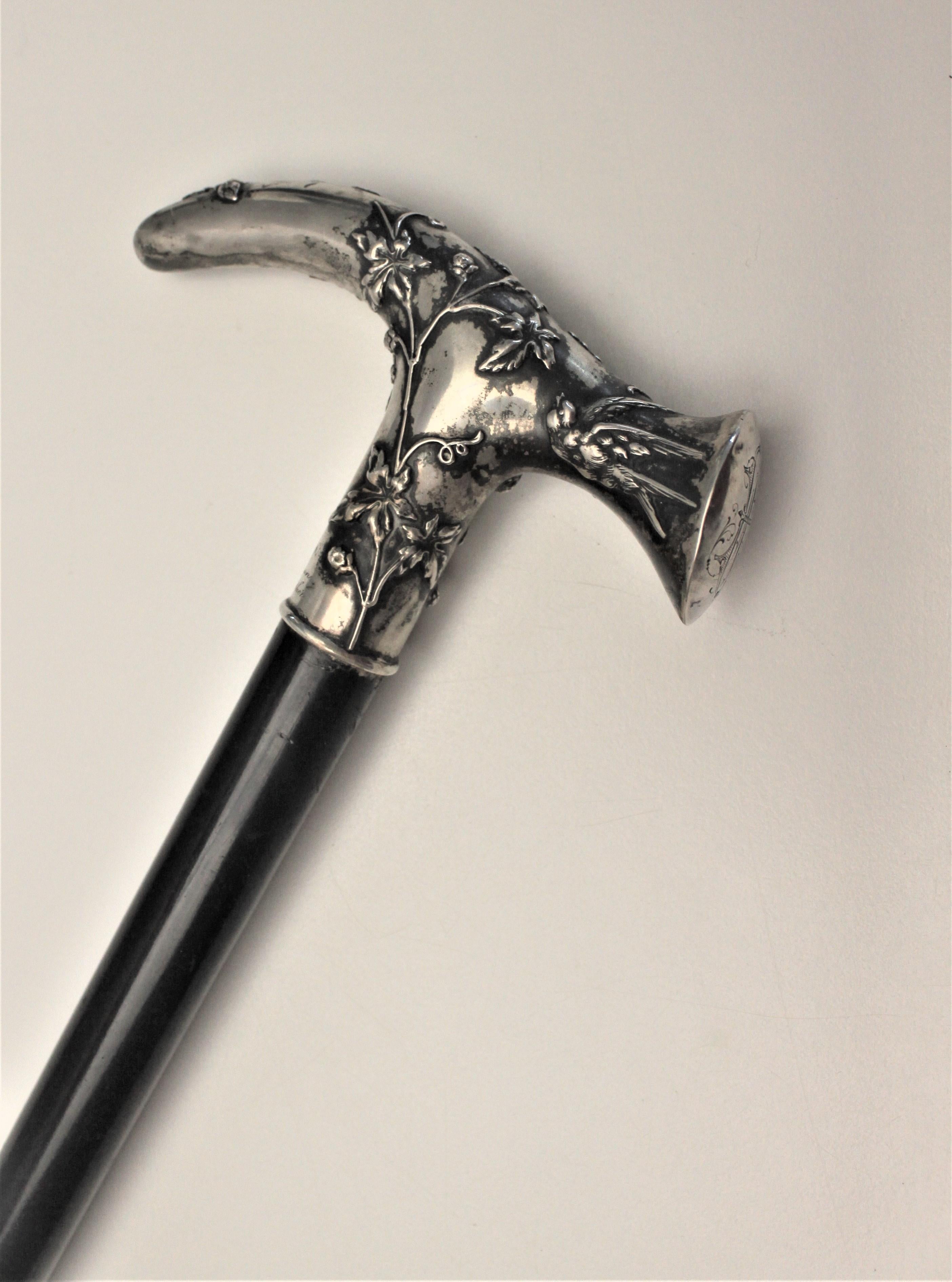 This cane is believed to have been made in England in approximately the year 1900 in the Victorian style. The cane has a sterling silver handle with ornate and intricately embossed vine decoration which functions as a grip when in use. The cane