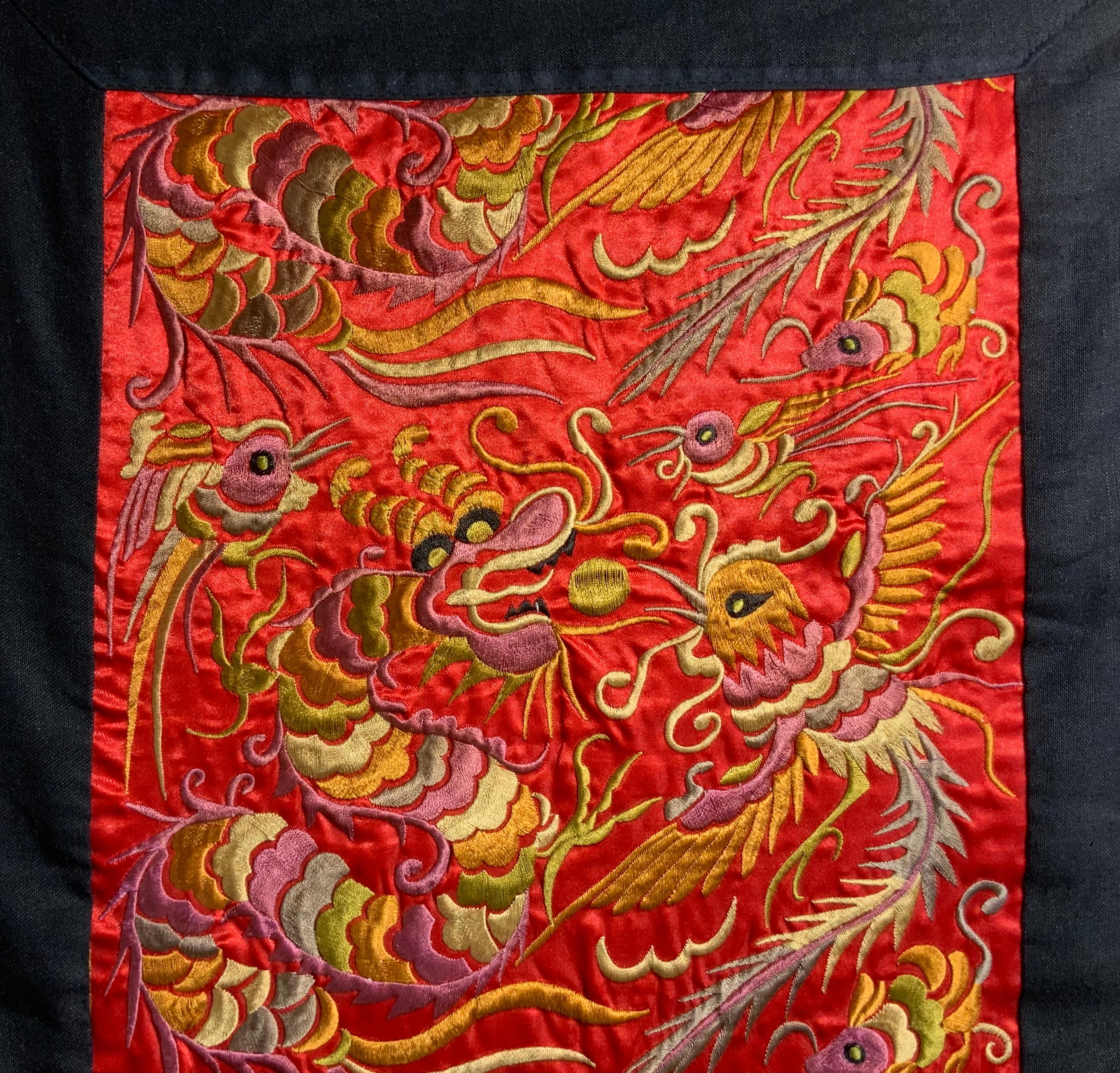 This is an incredible wall hanging made of embroidered silk satin. An antique piece from China, the traditional motifs show repeated scene of dragons and birds in perfect detail in polychrome silks. The hand embroidery is immaculate and shows a high