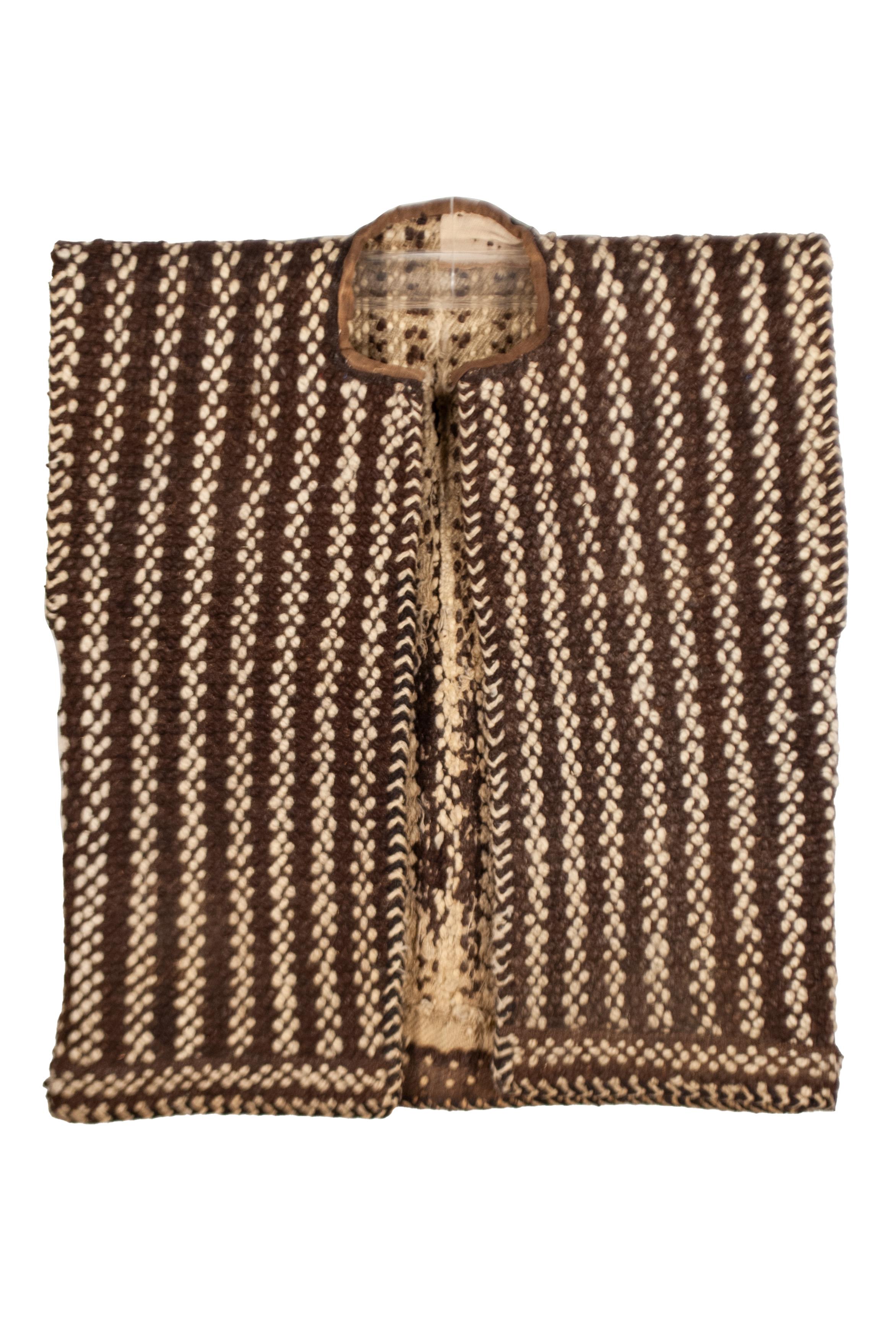 Antico gilet da pastore nomade ricamato, Tibet

Un raro esempio di gilet da pastore proveniente dal Tibet occidentale. Composto da una spessa lana naturale di pecora tibetana marrone, pesantemente ricamata con lana naturale bianca per rinforzarla e