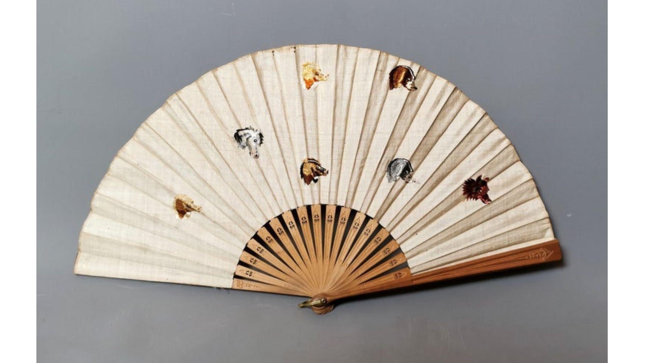 A very attractive and unusual antique embroidered fan.

Late Edwardian era it is a large size with carved and pierced wooden sticks and guards.

Made from cream silk with an array of embroidered dogs of different breeds and colours and a single grey