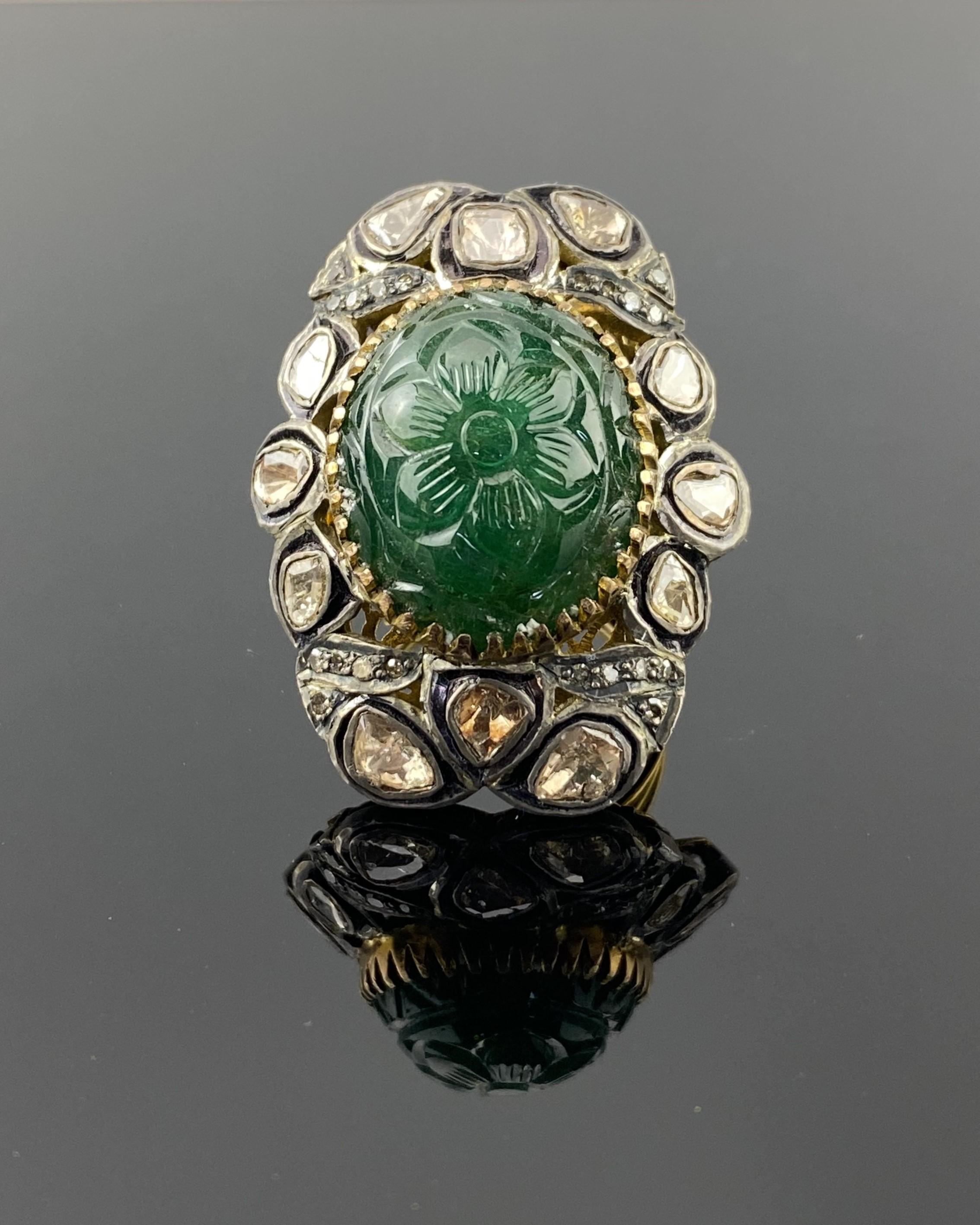 A statement cocktail ring, with a natural carved Emerald center stone, surrounded with sliced Diamonds set in Silver, with Gold polish. 
The ring is currently sized at US7, can be resized. 
Please feel free to message us for more information. 
We
