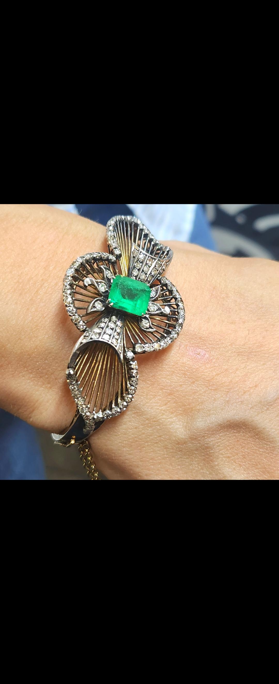 Bracciale bangle antico realizzato in Europa negli anni '50 del XIX secolo con un design a nastro inusuale e una lavorazione dettagliata, con al centro uno smeraldo verde naturale di 9,20 mm×8 mm, stimato 3 carati, affiancato da diamanti taglio