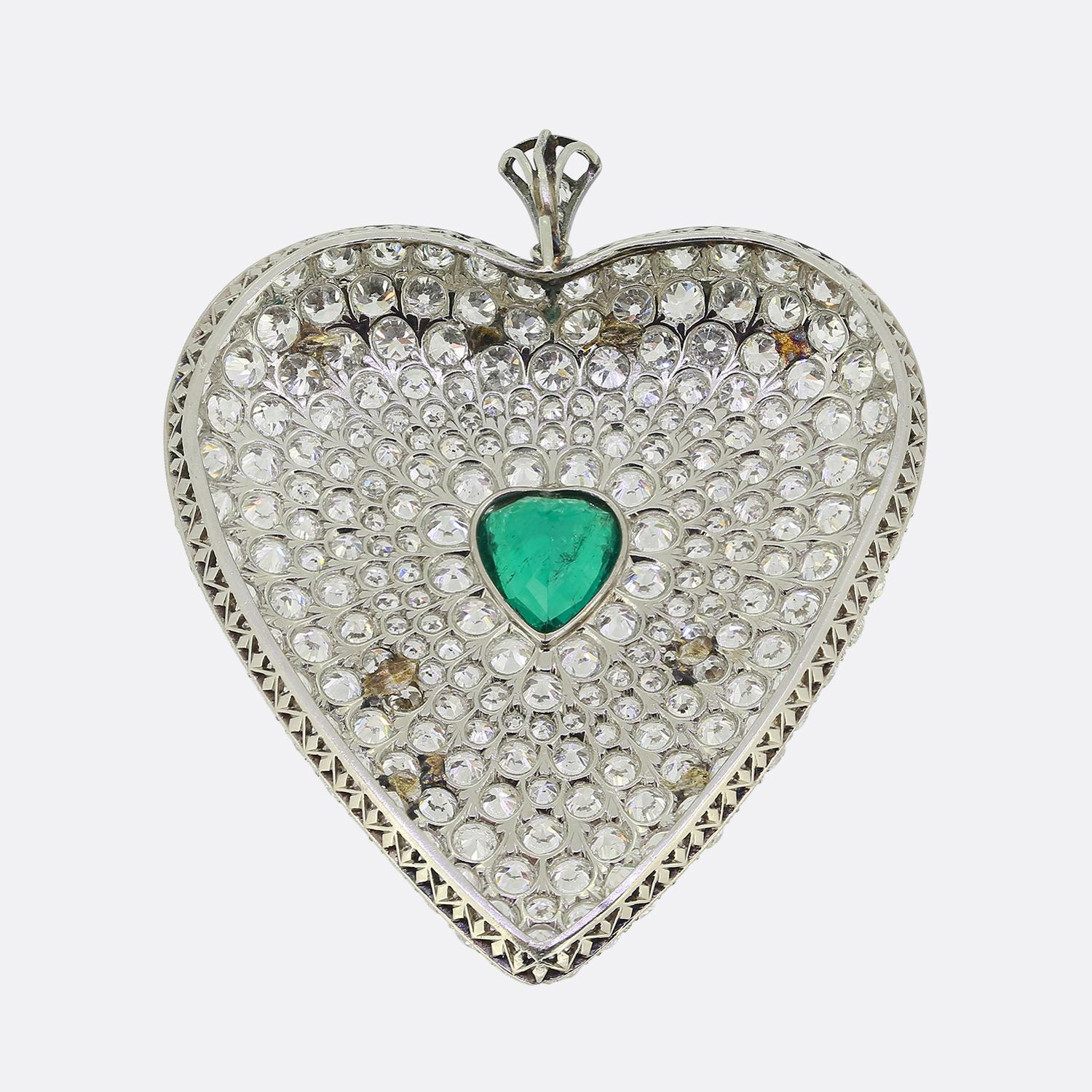 Here we have a gorgeous oversized heart-shaped pendant taken from the Art Deco movement. This romantic piece has been crafted from platinum into the shape of a love heart with a matching heart-shaped emerald sitting at the centre of the face. This