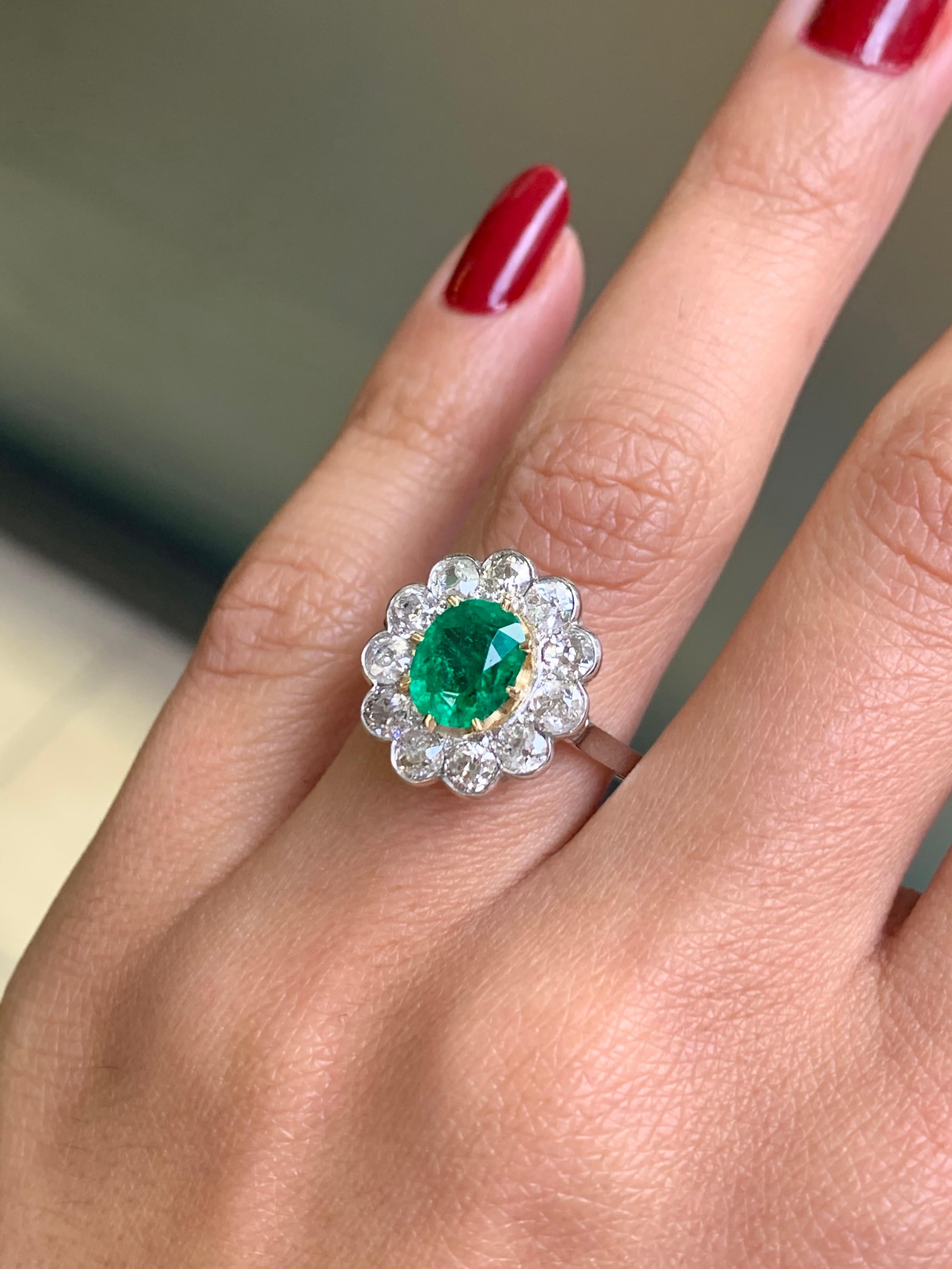 Oval Cut Antique Emerald and Diamond Platinum Coronet Cluster Ring, circa 1920s