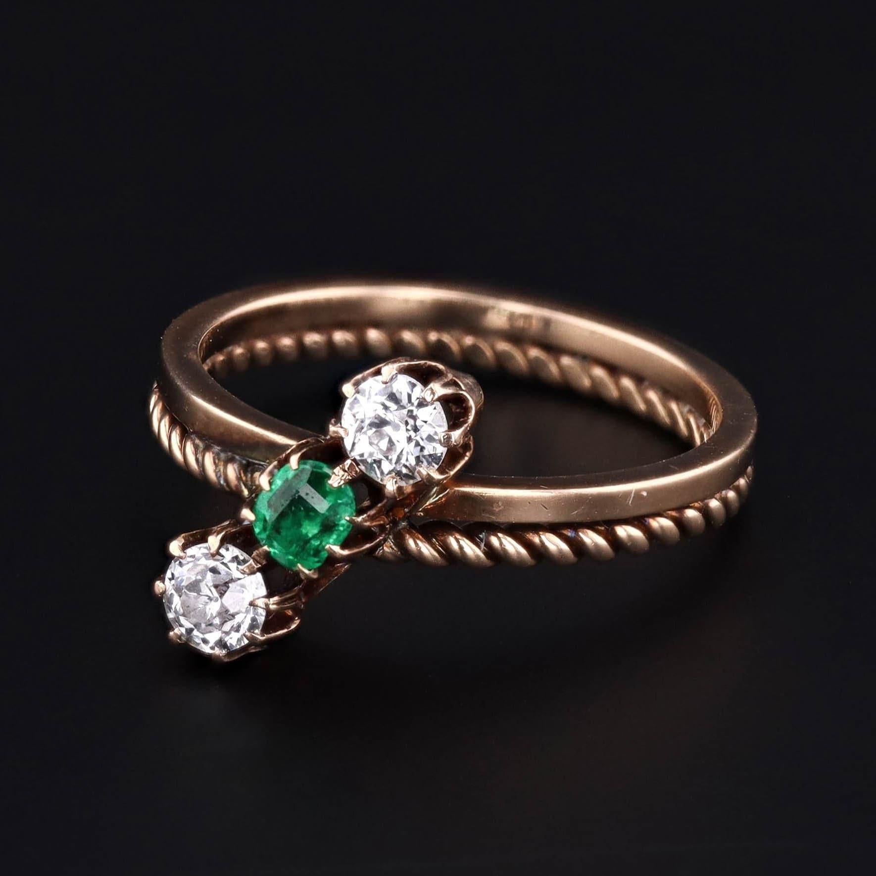 An alluring slant of gemstones work almost like a bow against this unique double band design!

The Victorian ring (circa 1880-1900) features a vivid, slightly bluish green antique cushion cut emerald & two old European cut diamonds. The diamonds