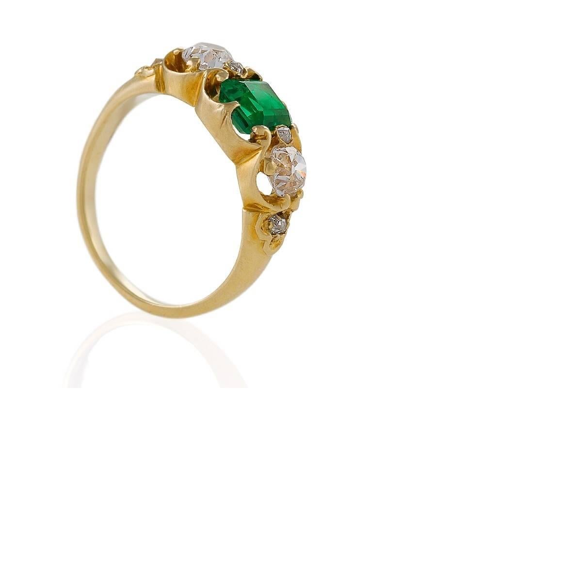 An Antique 18 karat yellow gold ring with emerald and diamonds. The ring has an emerald-cut emerald with an approximate total weight of .80 carat, and 4 old European-cut diamonds with an approximate total weight of .70 carat. The ring is designed in