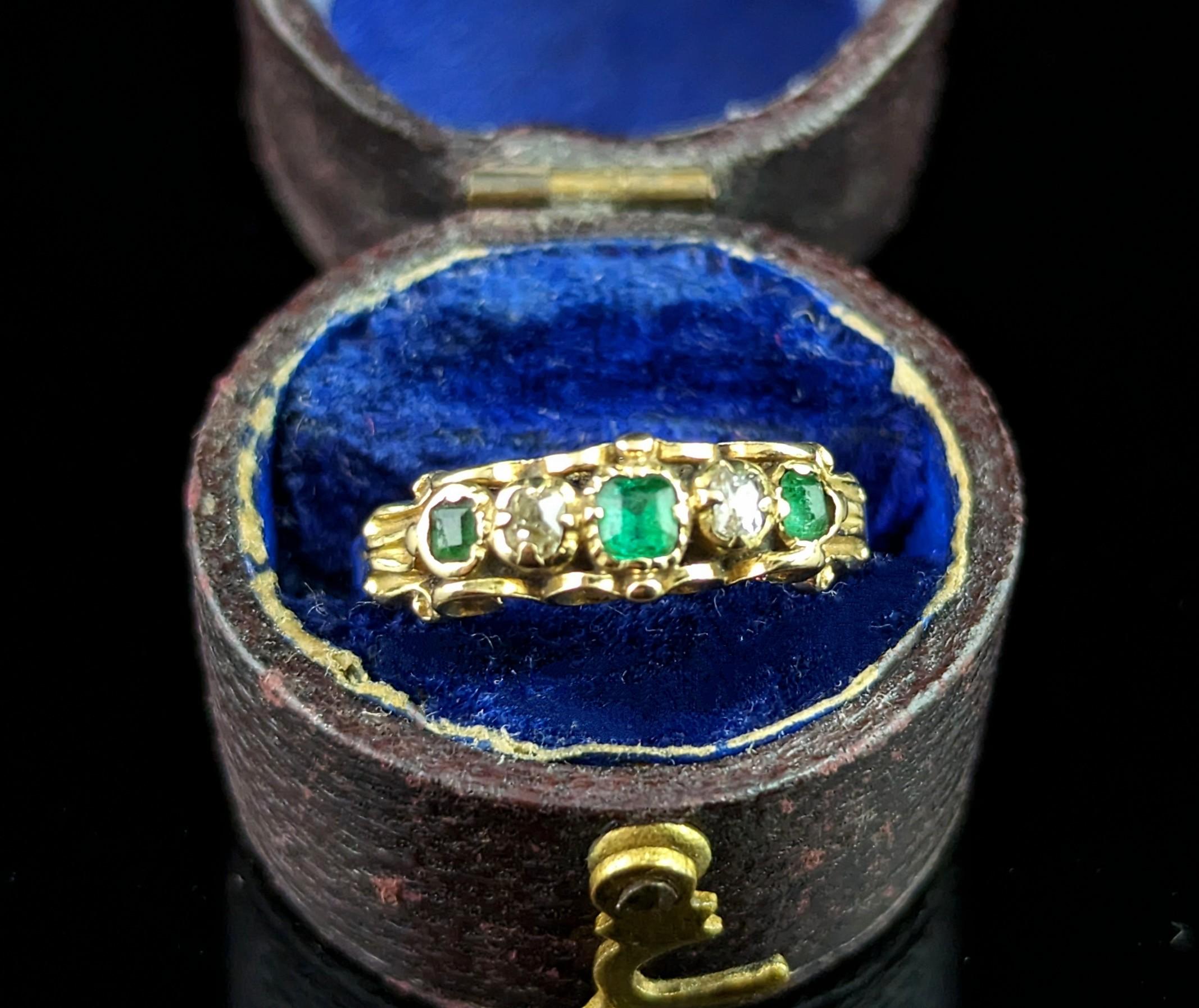 This antique Emerald and Diamond ring exudes Victorian luxury.

It is an early Victorian piece crafted in rich 18ct yellow gold, set to the face with a row of gems, three emeralds and two old cut diamonds.

The setting has beautiful scrollwork top